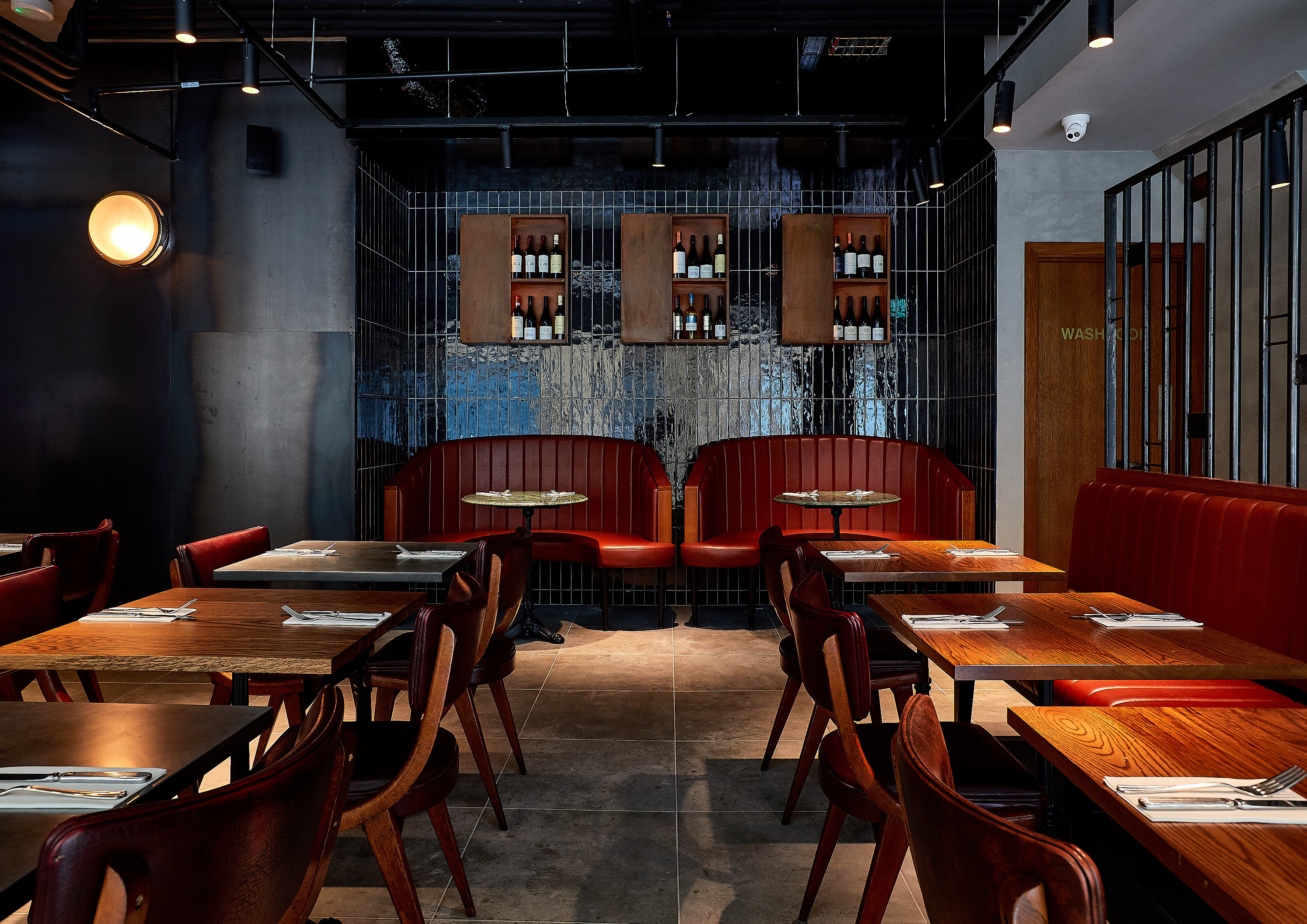 Modern restaurant interior with wooden tables and red banquettes for events at Gunpowder Tower.