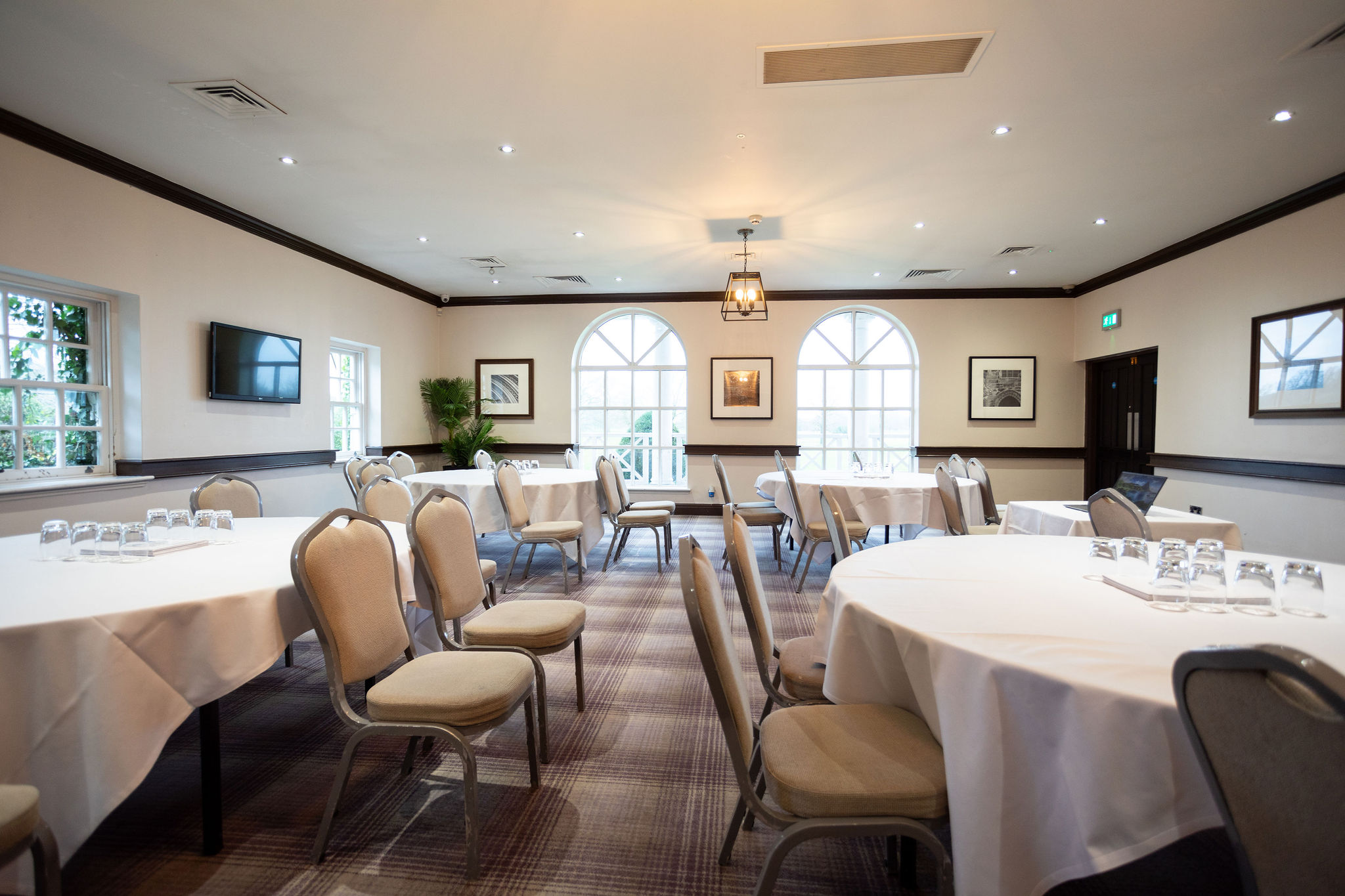 Thomas Suite at Mottram Hall, bright meeting room with round tables for corporate events.