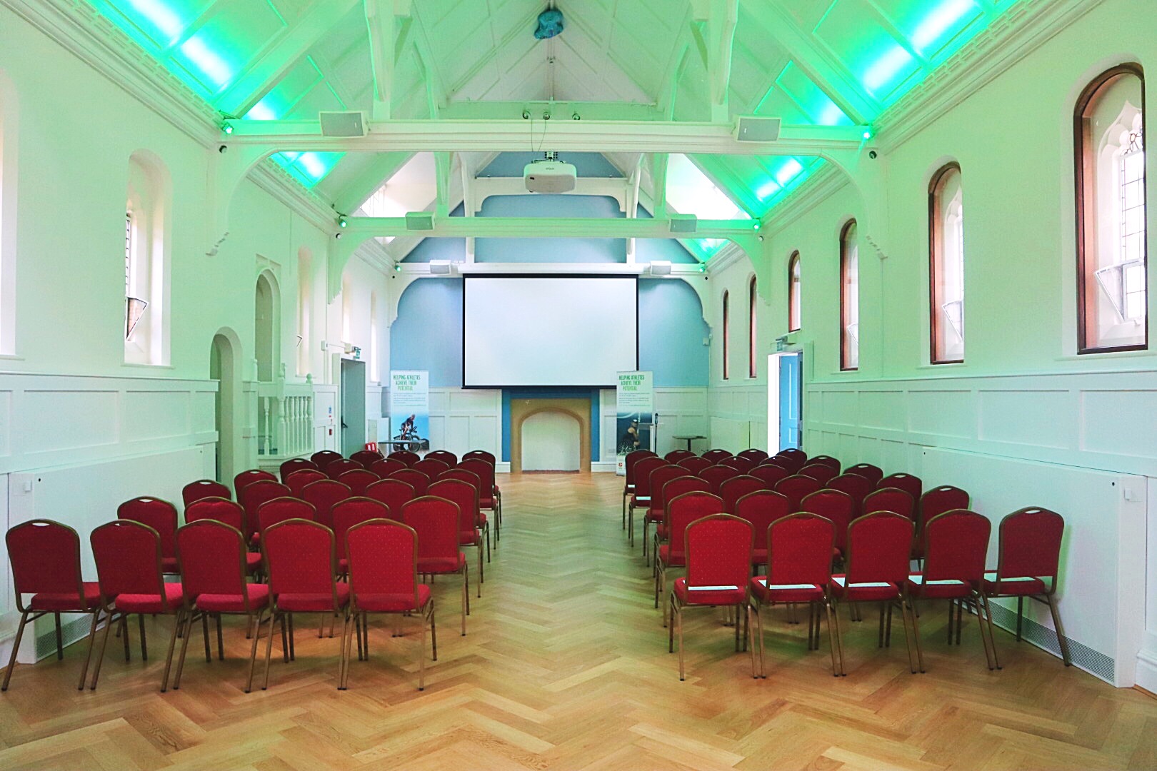 Byculla Suite in Ashburton Hall, Croydon: modern event space with red chairs for conferences.