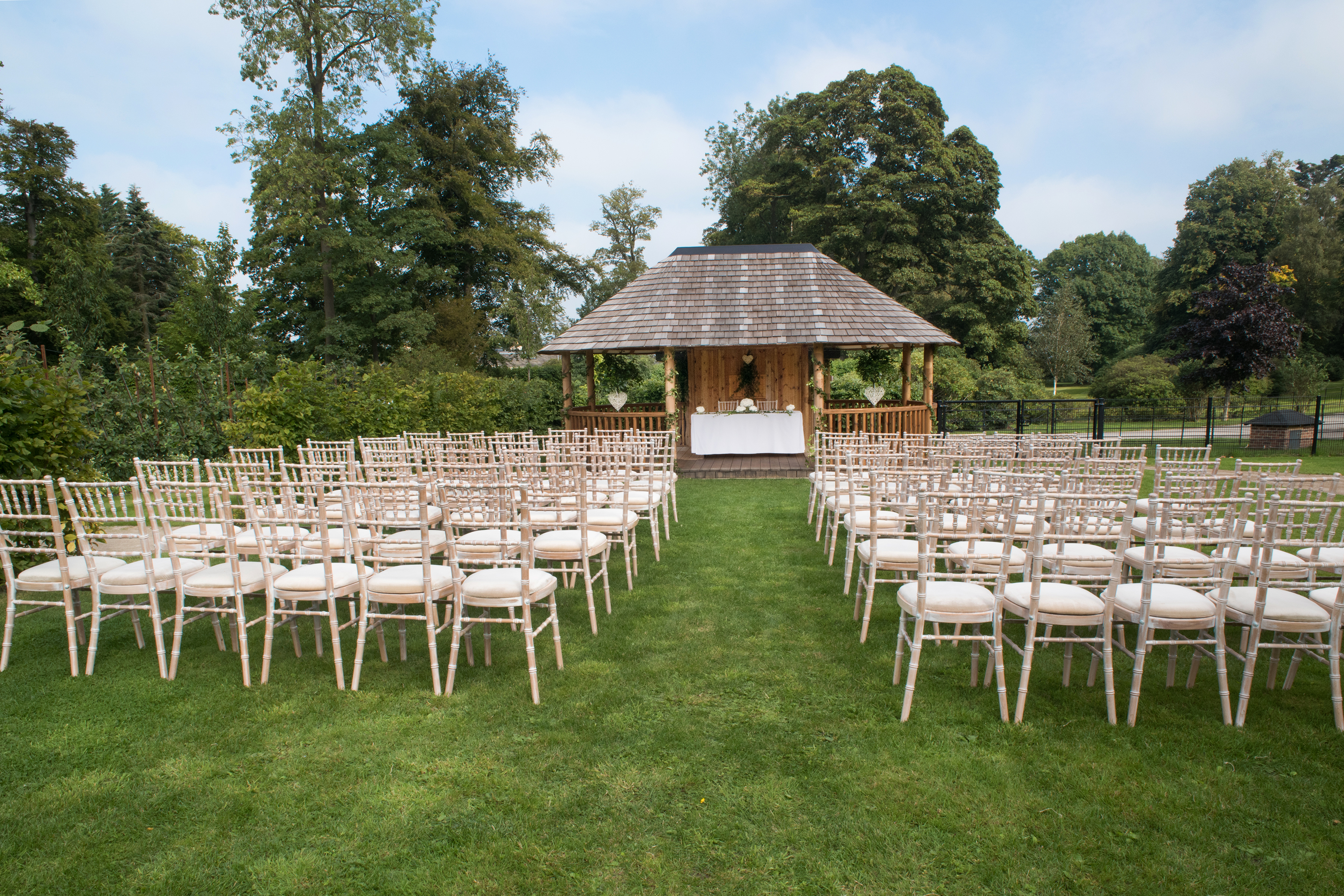Outdoor wedding venue at Rudding Park with elegant chairs and charming gazebo.