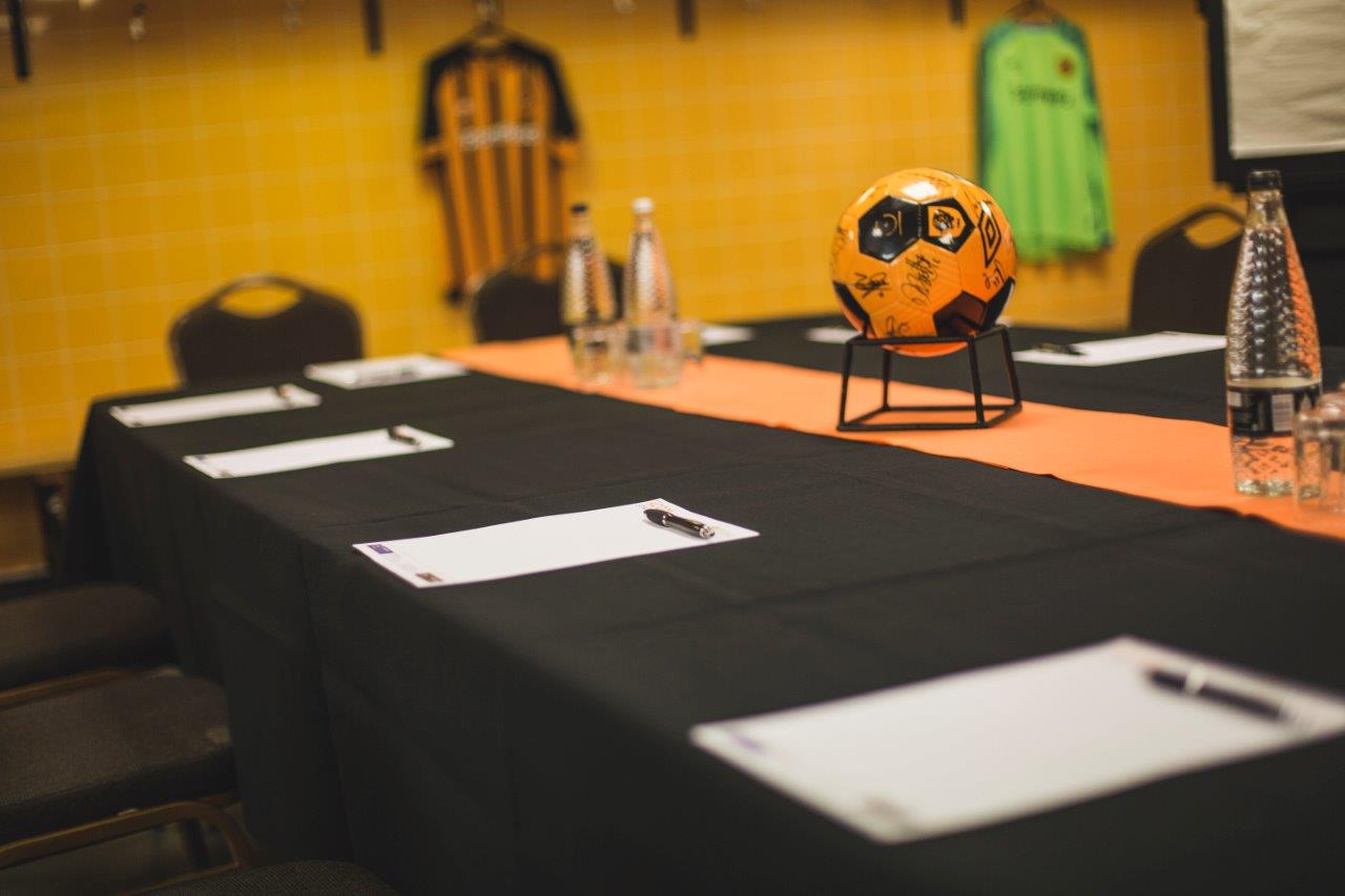 MKM Stadium changing rooms with soccer ball centerpiece for sports event meeting.