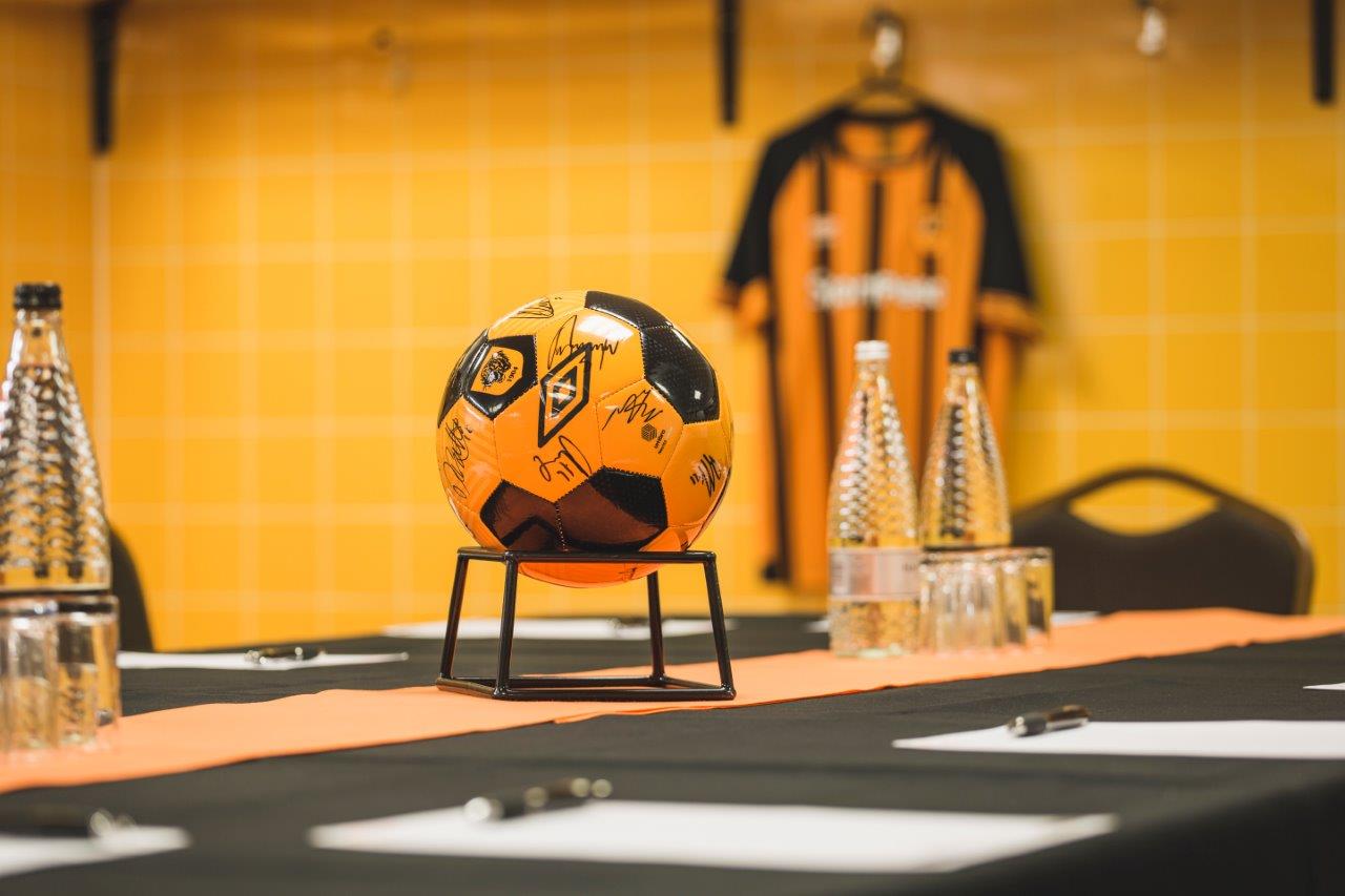 MKM Stadium changing rooms with signed soccer ball, ideal for sports events and team-building.