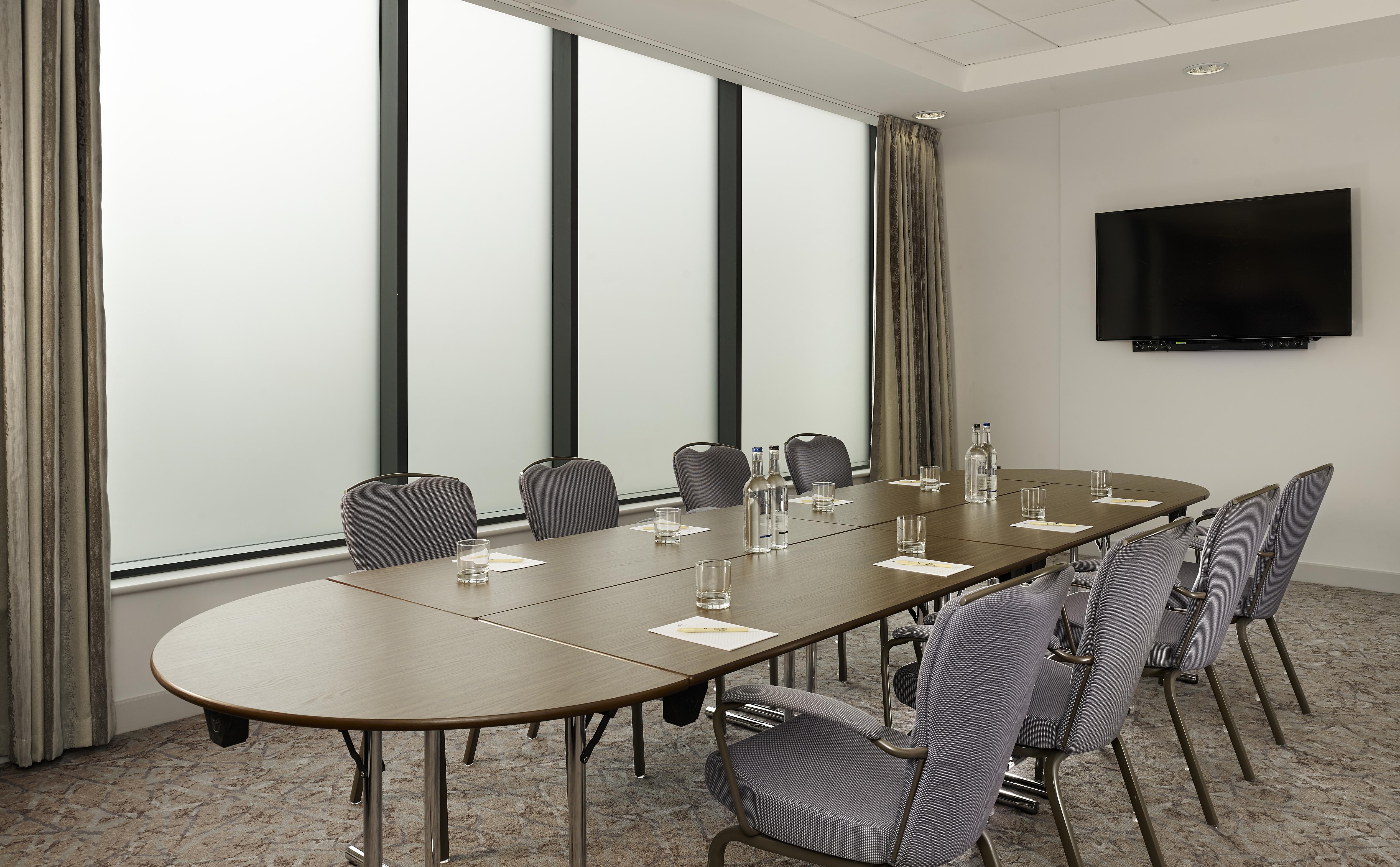 Modern meeting room with oval table and ergonomic chairs at DoubleTree by Hilton.