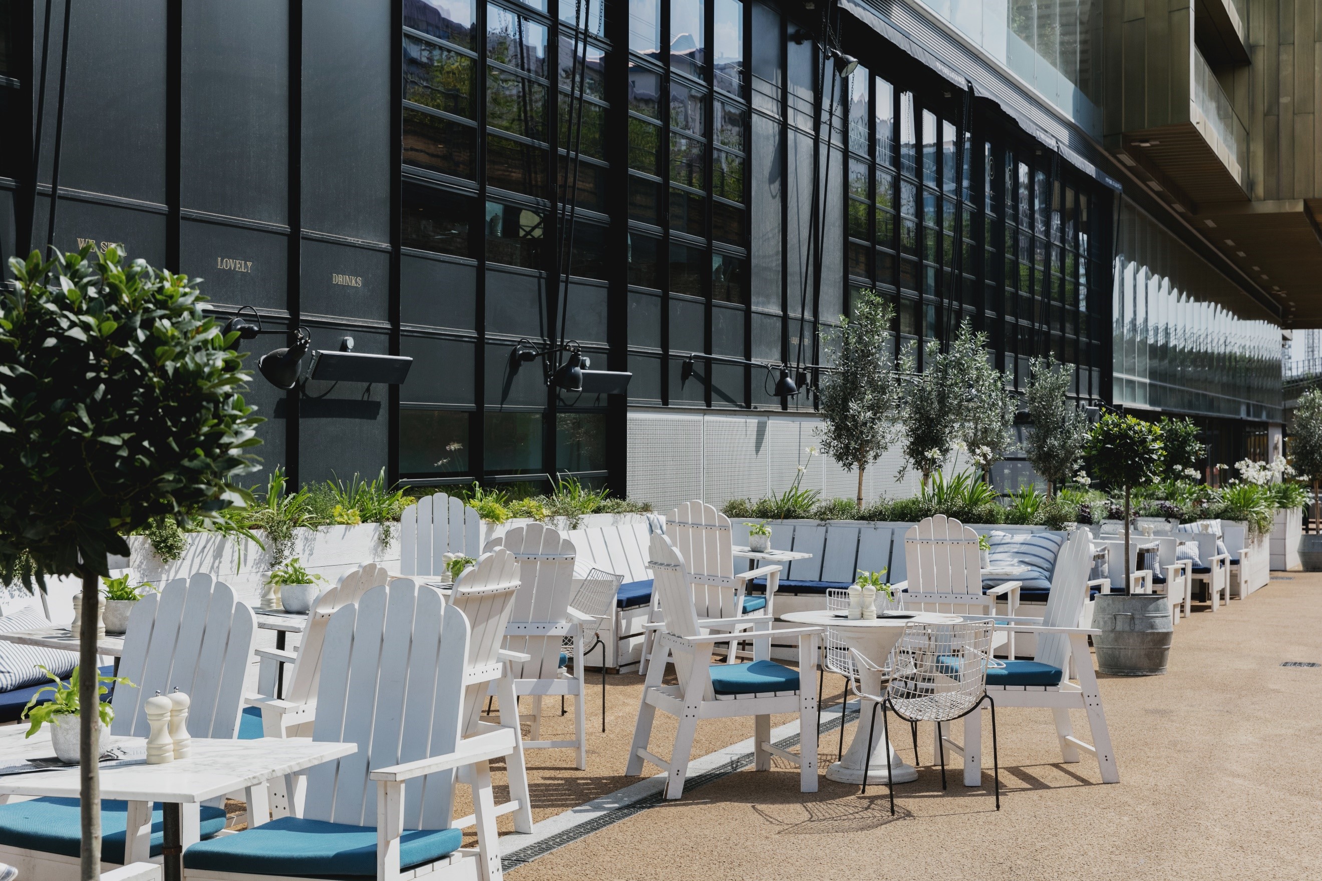 Stylish outdoor event space at The River Bar with white Adirondack chairs, ideal for networking.