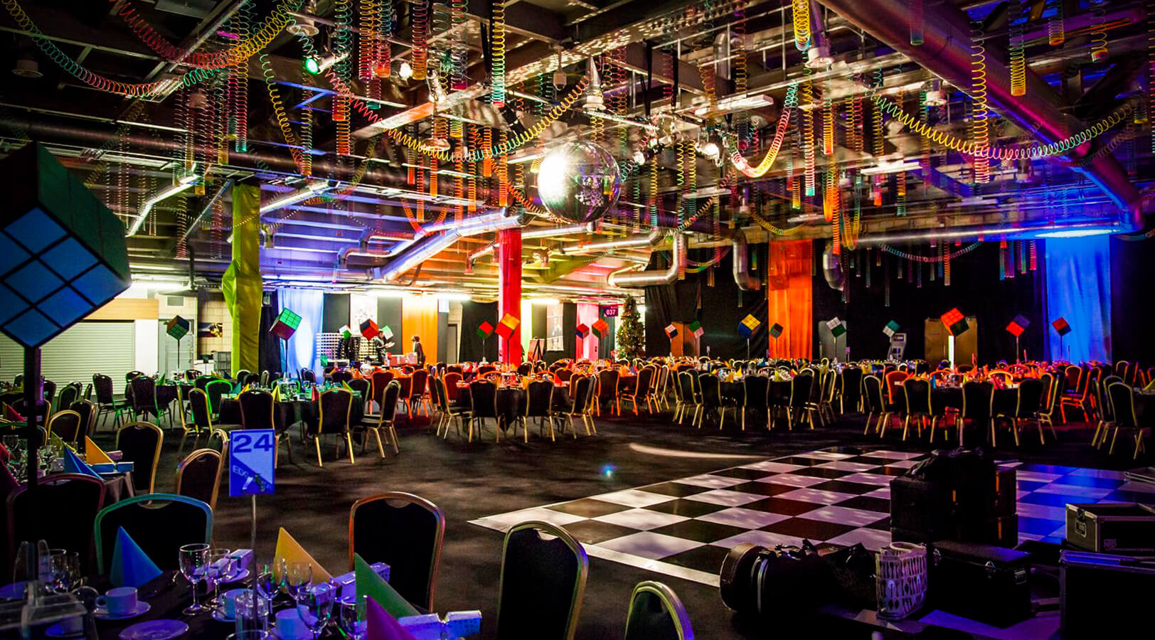 Retro-themed gala at Edgbaston Stadium with checkerboard dance floor for corporate event hire.