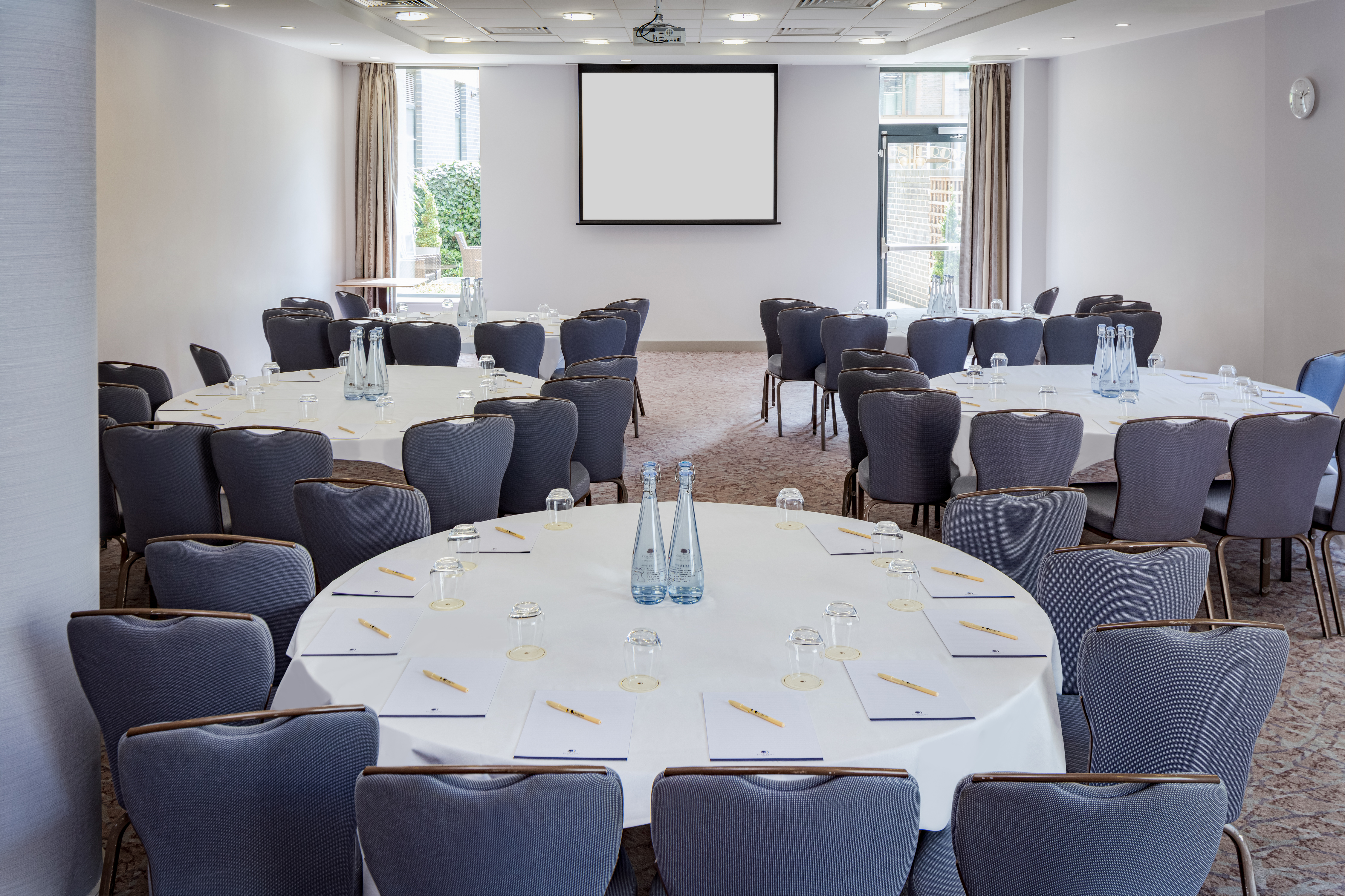 Claremont Suite meeting space with round tables, ideal for professional events and networking.