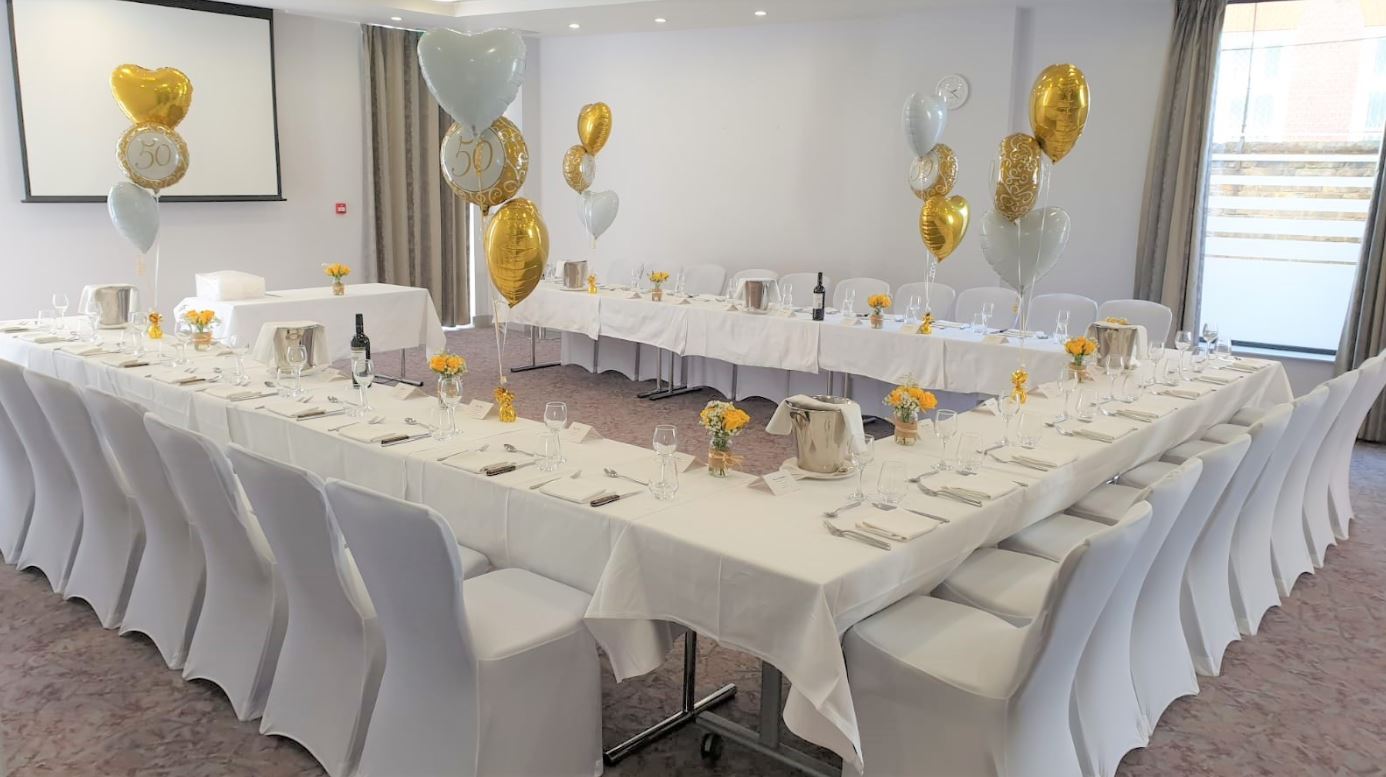 Claremont Suite event space with elegant table setup for formal gatherings and networking.