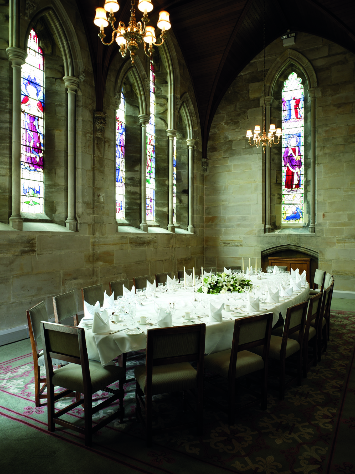 Elegant dining table with stained glass at Ashdown Park Hotel for special events.