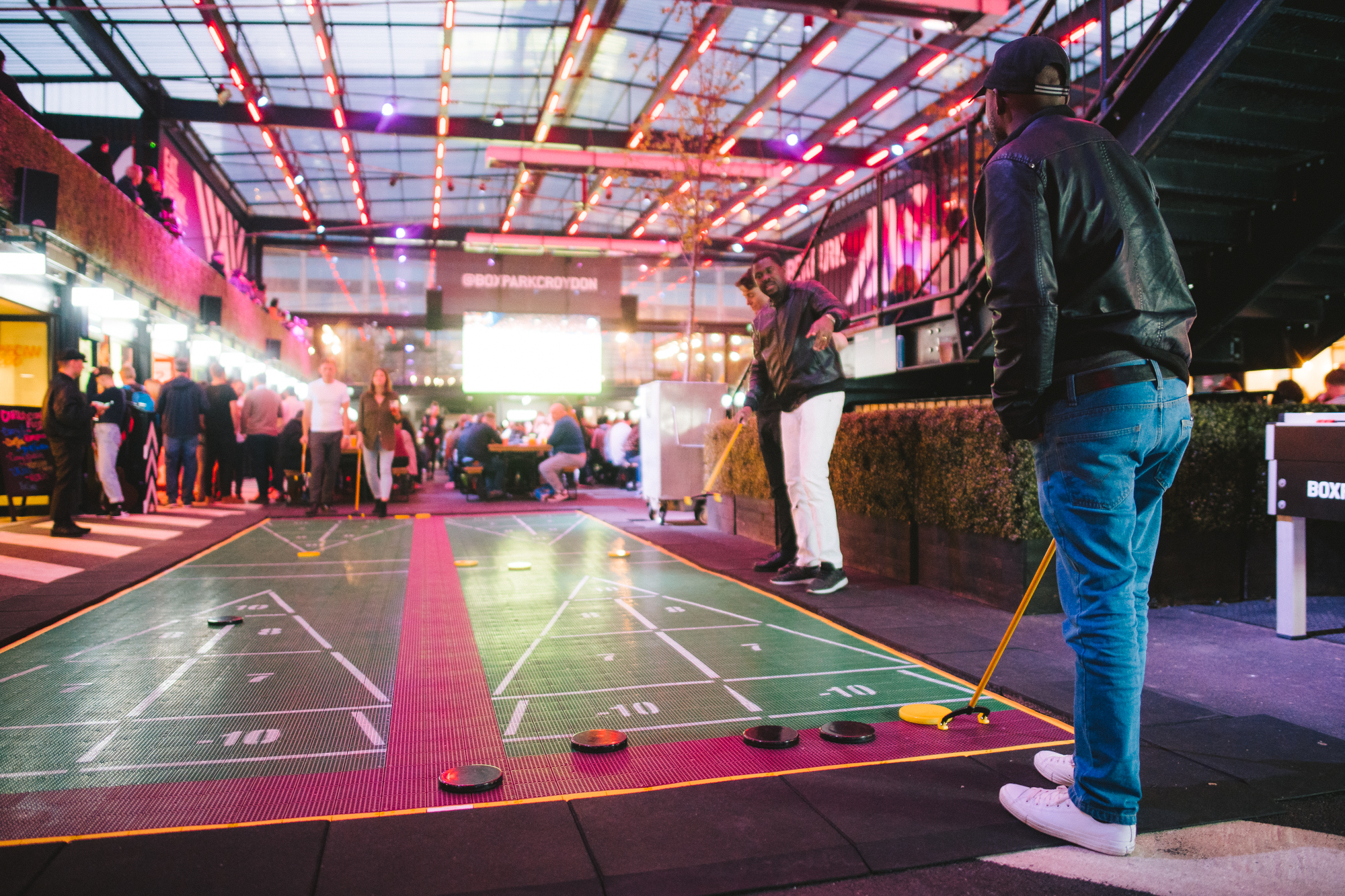 Vibrant shuffleboard event space at Boxpark Croydon for corporate gatherings.