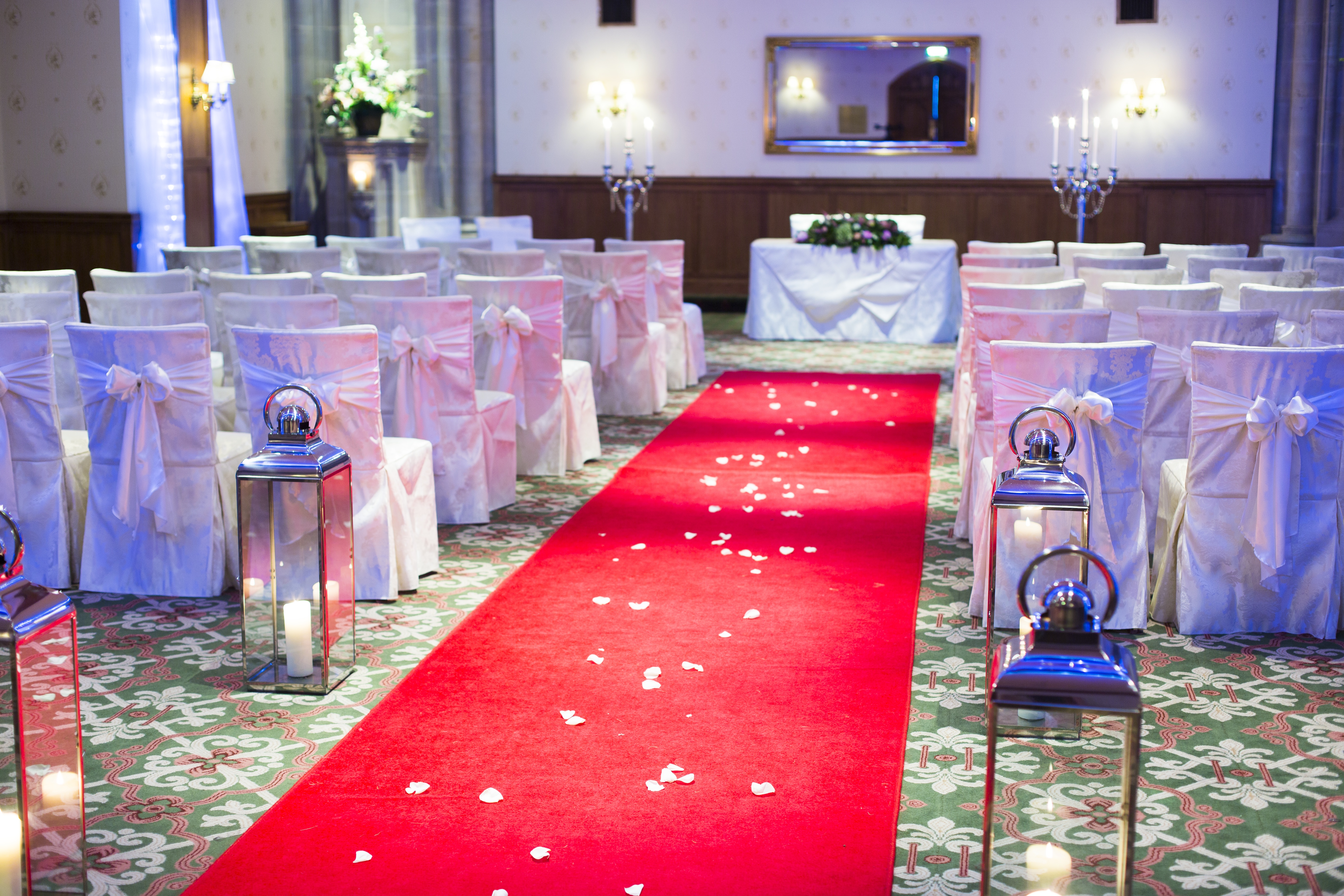John Haywood at Ashdown Park Hotel, elegant wedding ceremony with red carpet and white chairs.