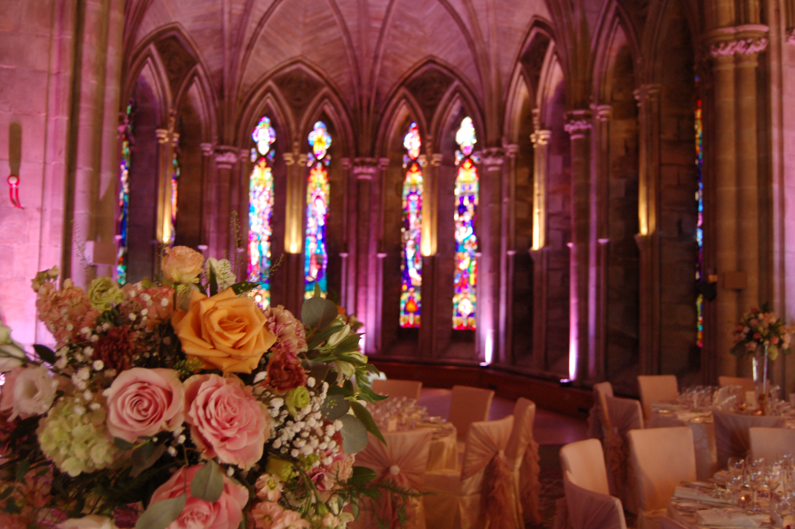 Elegant event space with floral arrangements and stained glass at Ashdown Park Hotel.