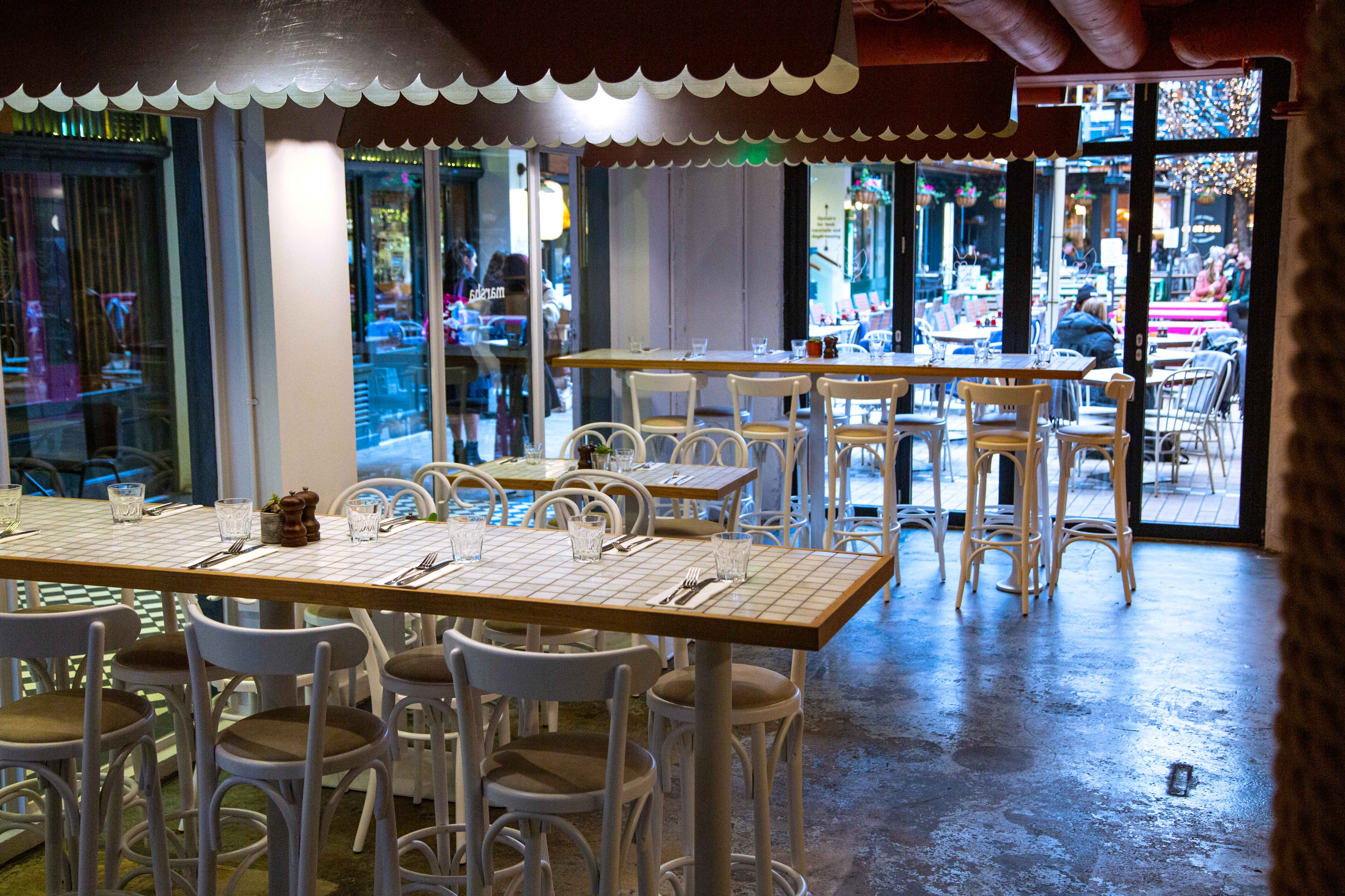 Modern restaurant interior with natural light, perfect for intimate gatherings and meetings.