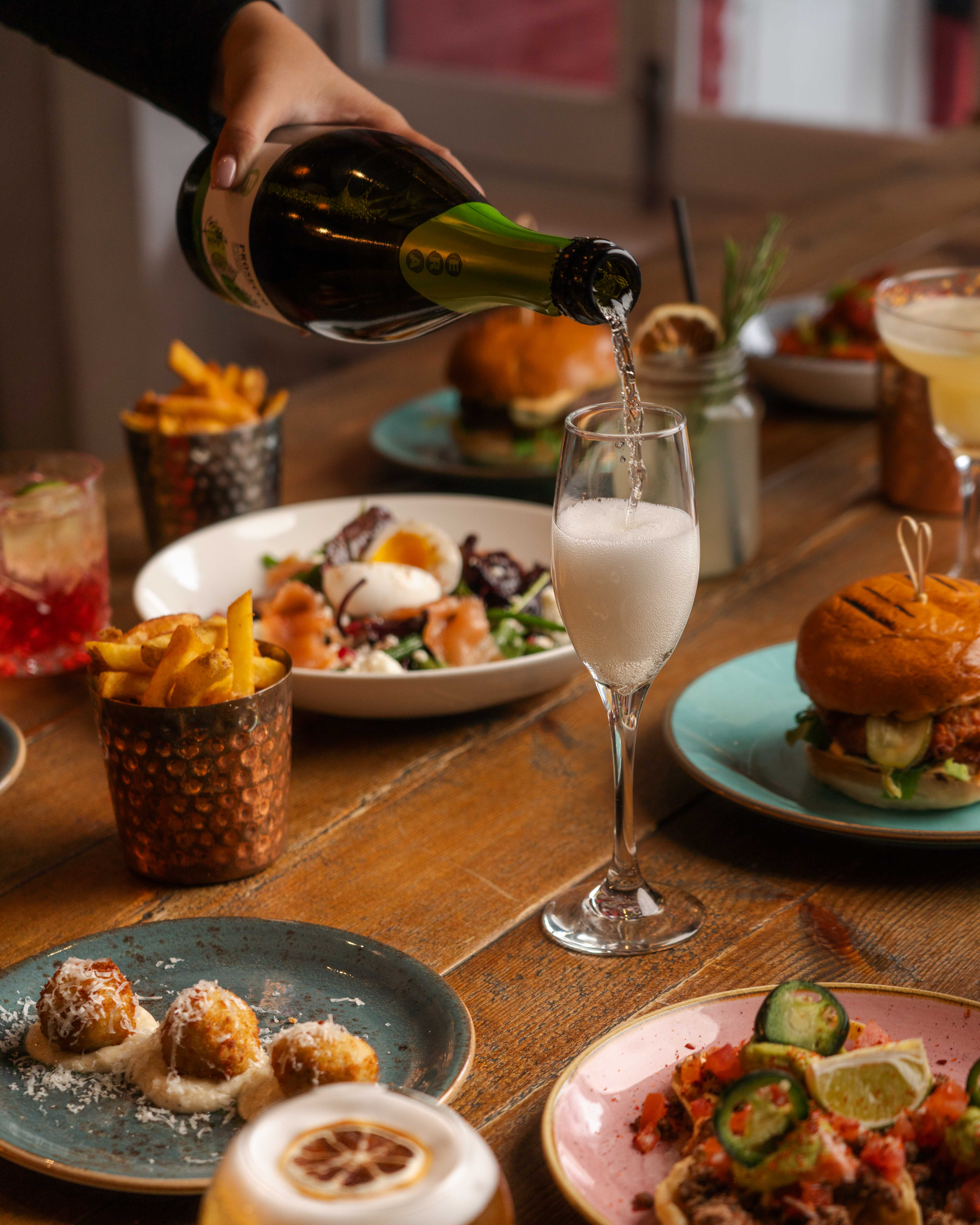 Upscale dining table with gourmet sliders and cocktails at Paradiso Soho for events.