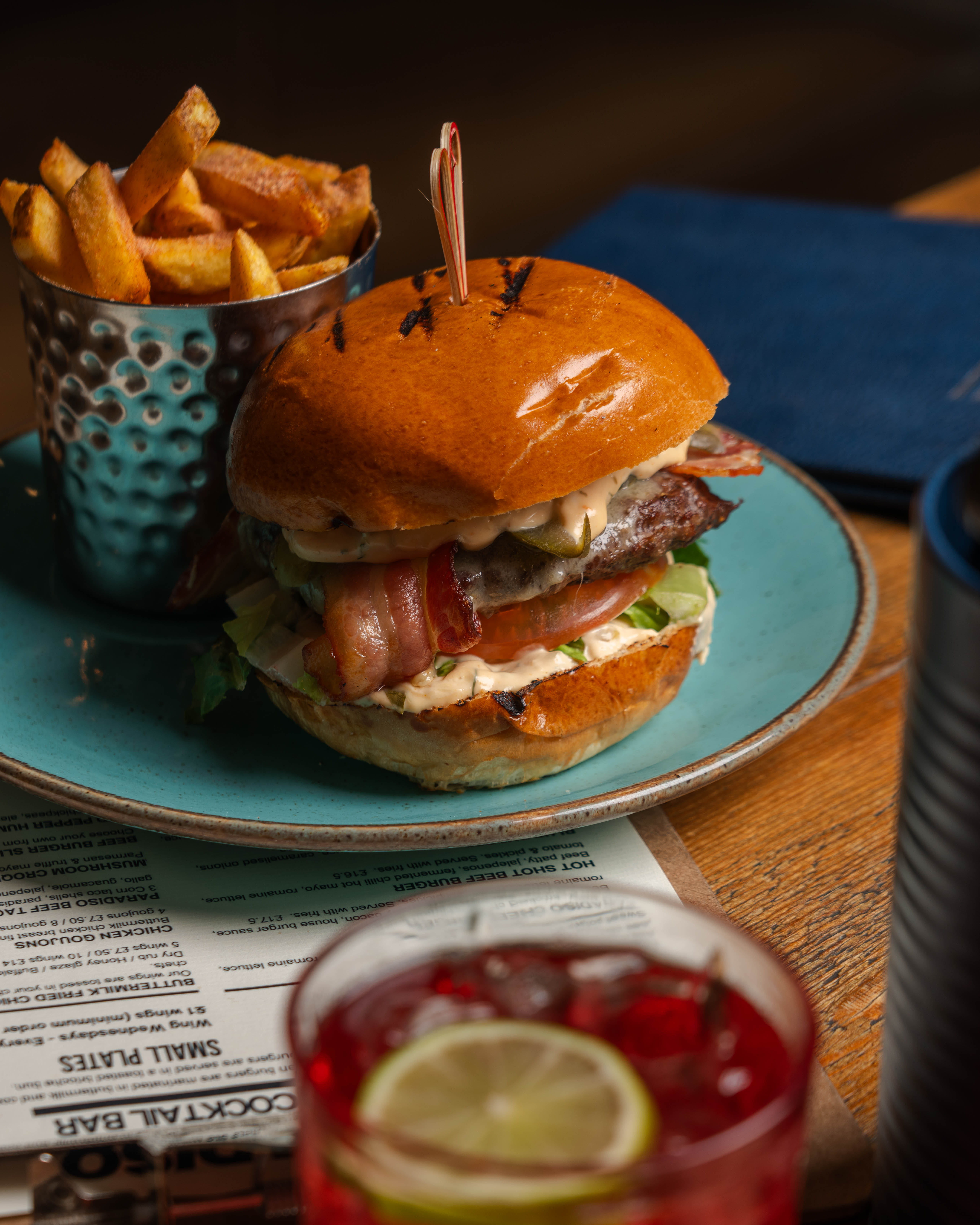 Gourmet burger on blue plate, ideal for catering at events and gatherings.