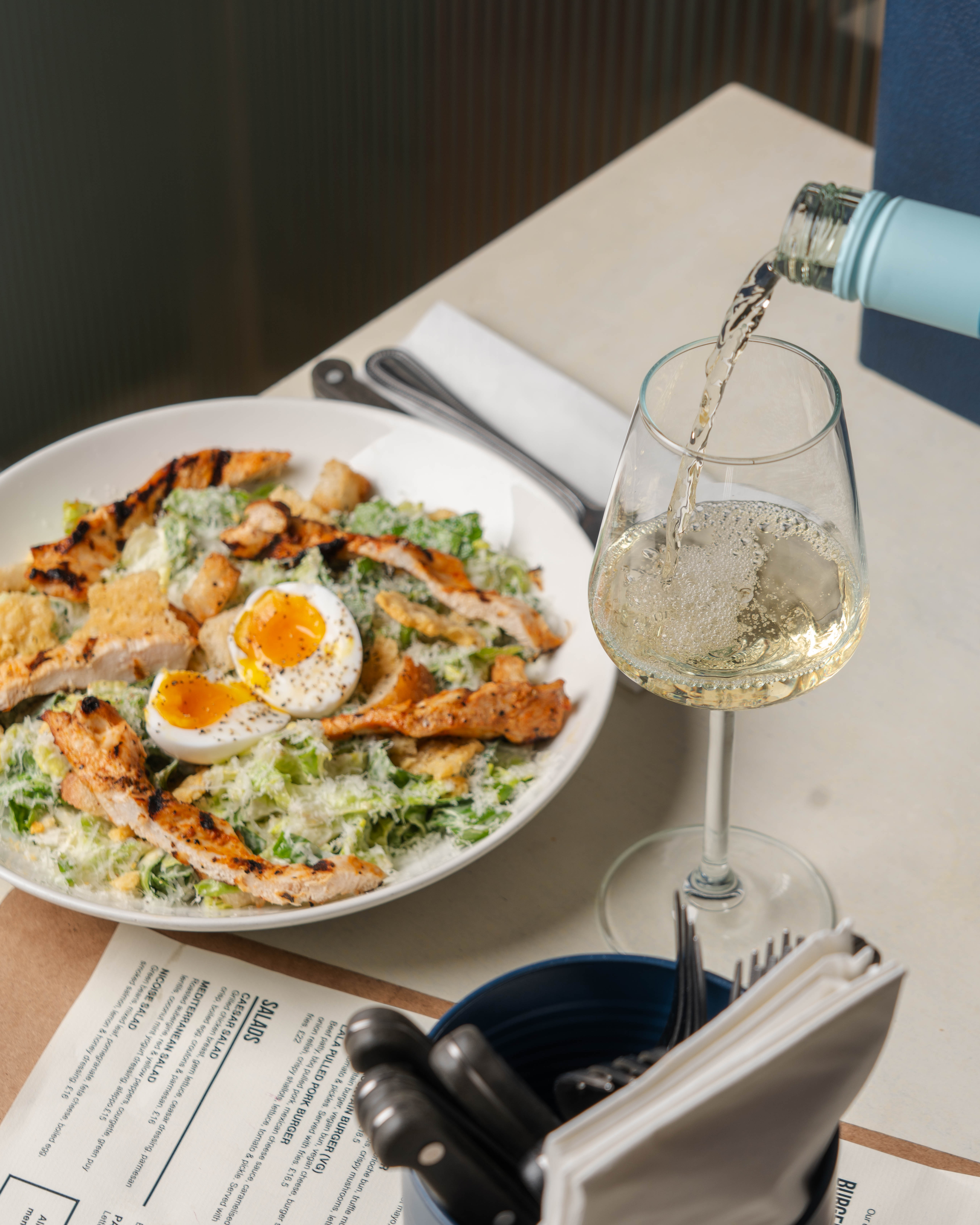 Elegant salad with grilled chicken and sparkling wine at Paradiso Soho event.