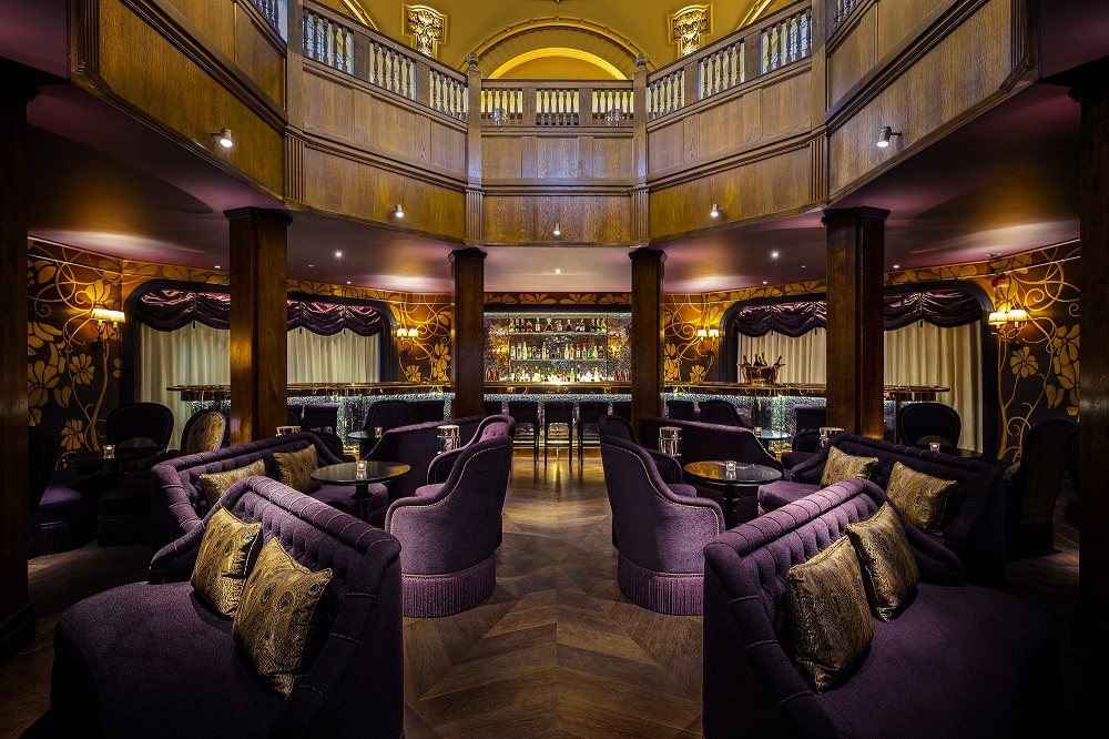 Elegant event space at L'oscar London with purple seating for upscale receptions.