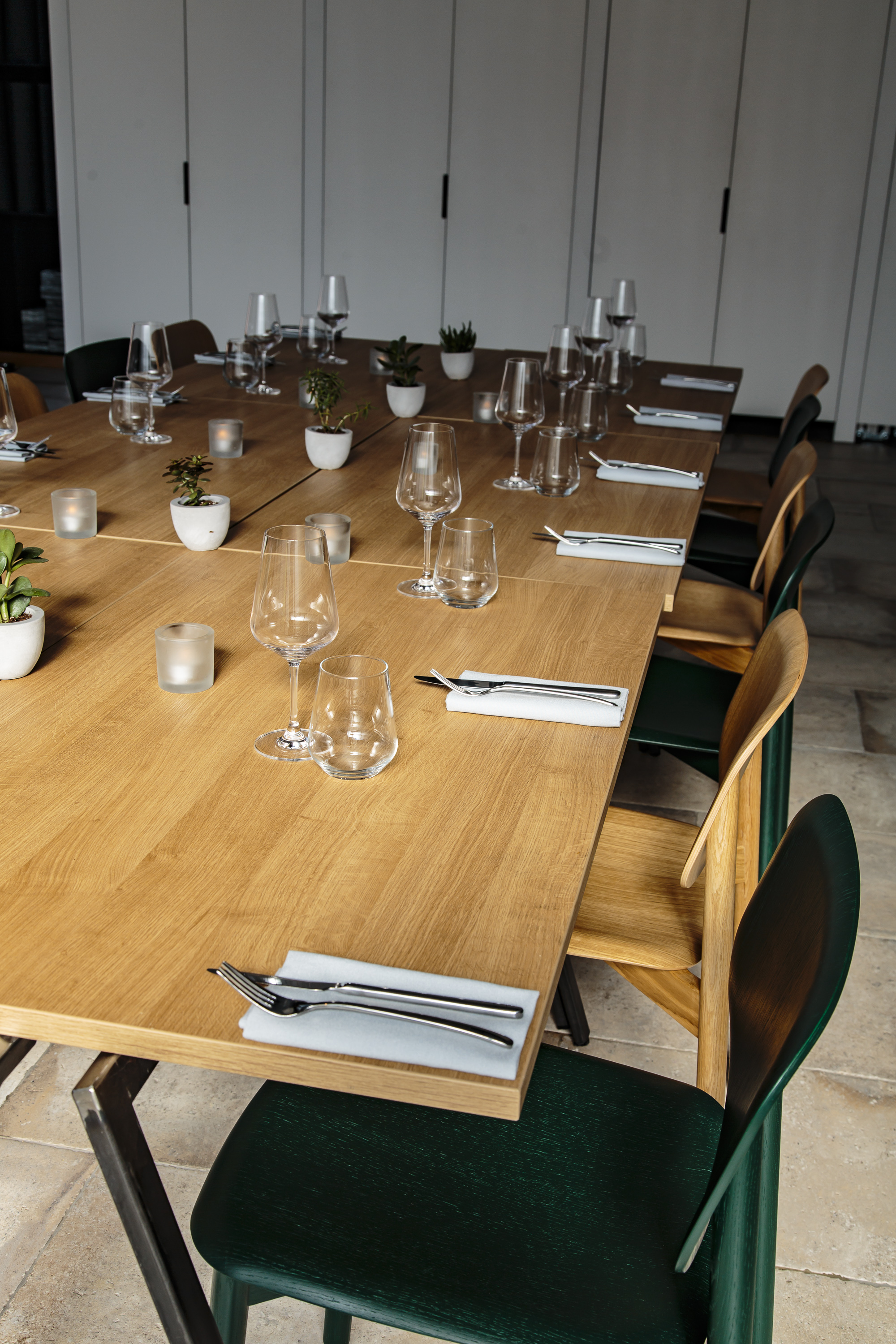 Intimate dining setup with elegant glassware and natural wood finish for events.
