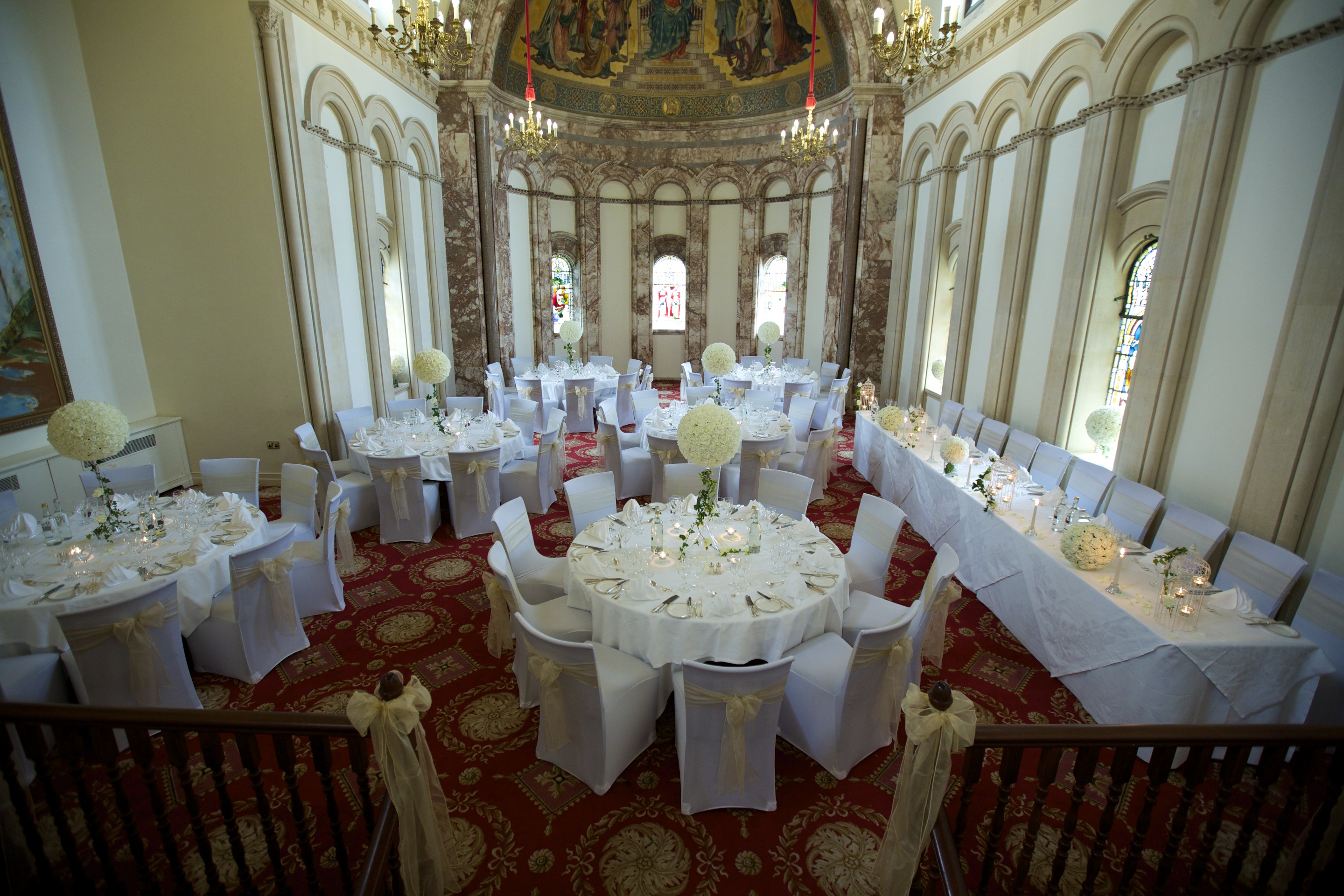 Elegant event space at Luton Hoo Hotel with floral centerpieces, ideal for weddings.