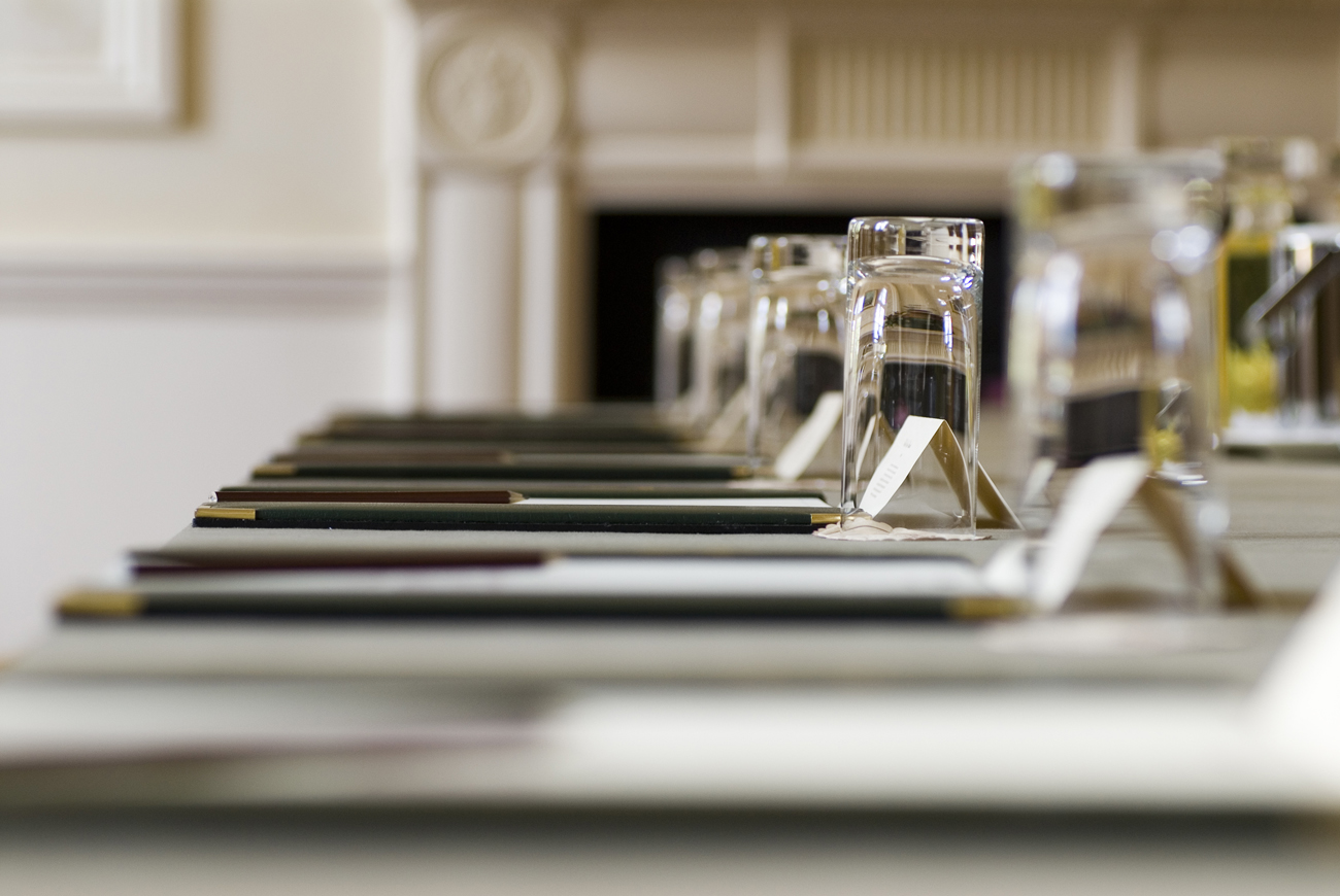Newnham Suite meeting setup at Tylney Hall, featuring elegant notepads and glassware.