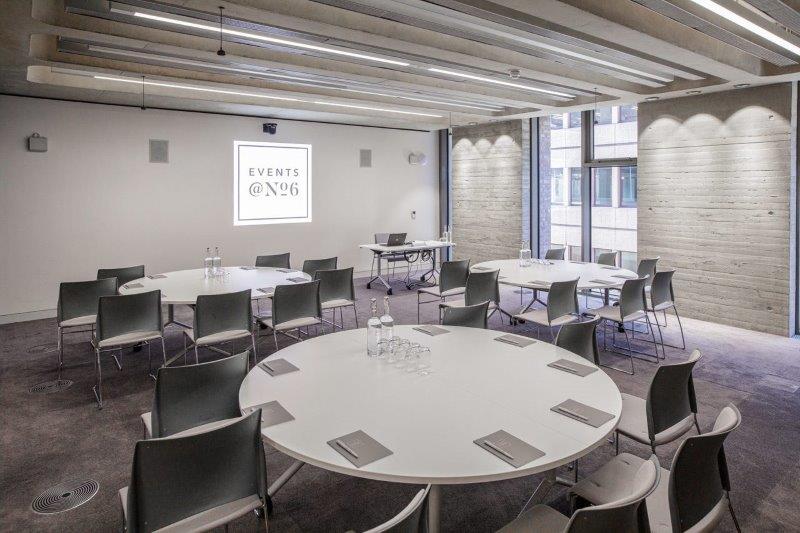 Modern meeting room with circular tables, perfect for events and workshops.