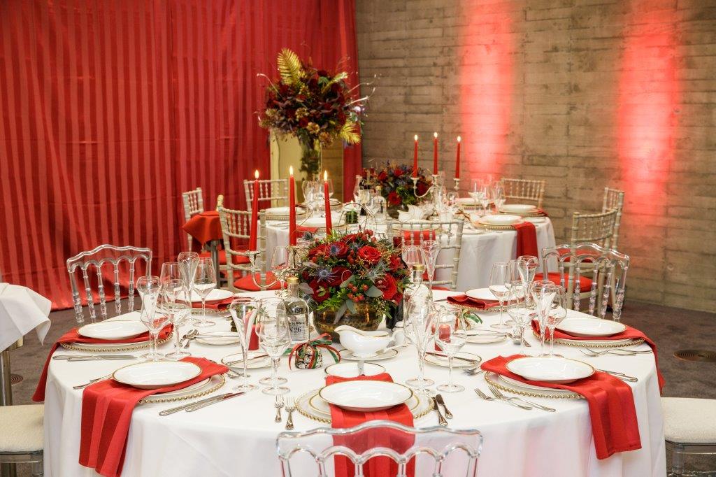 Elegant dining table with red accents for formal events and galas at Alie Room.
