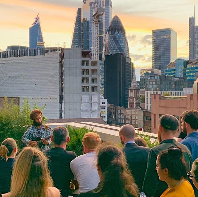 Intimate outdoor event in Terrace Room with live musician and urban backdrop.