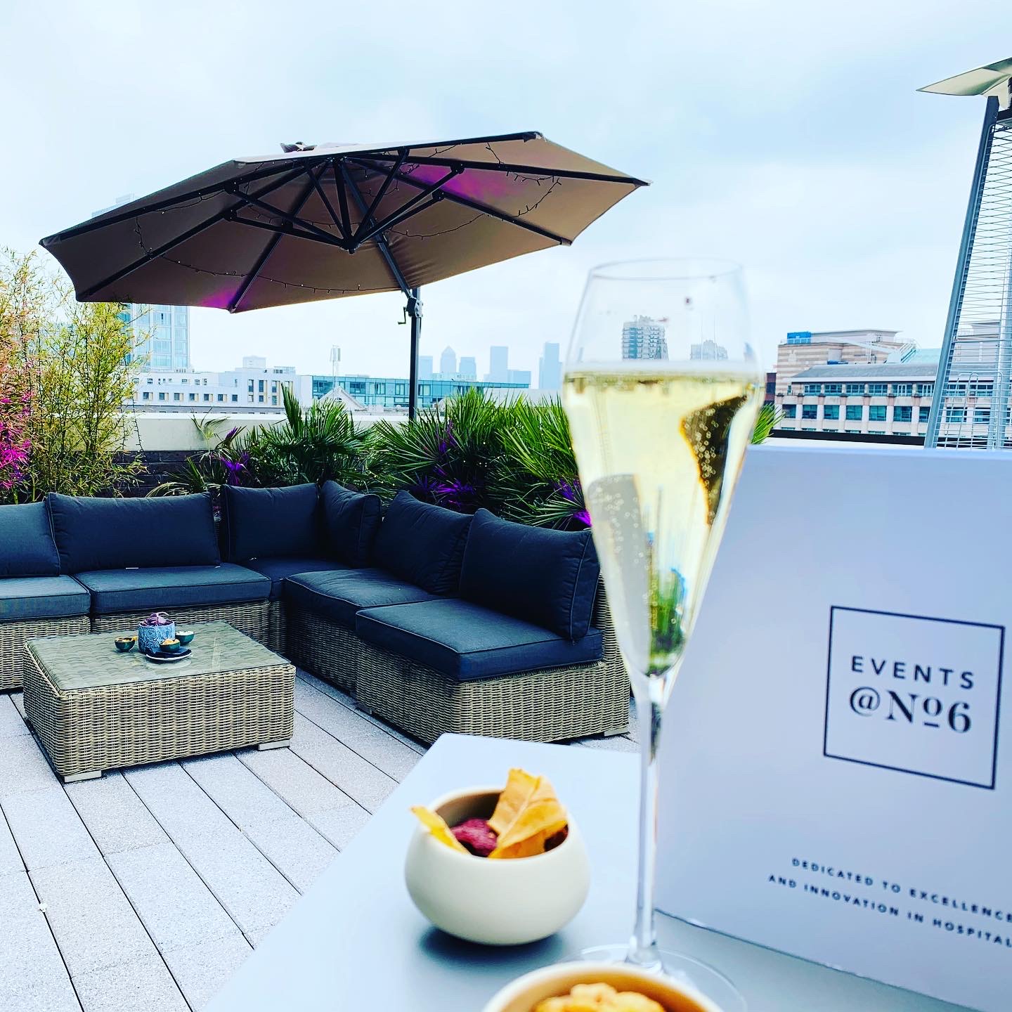 Stylish rooftop event space with elegant seating and urban skyline for upscale gatherings.