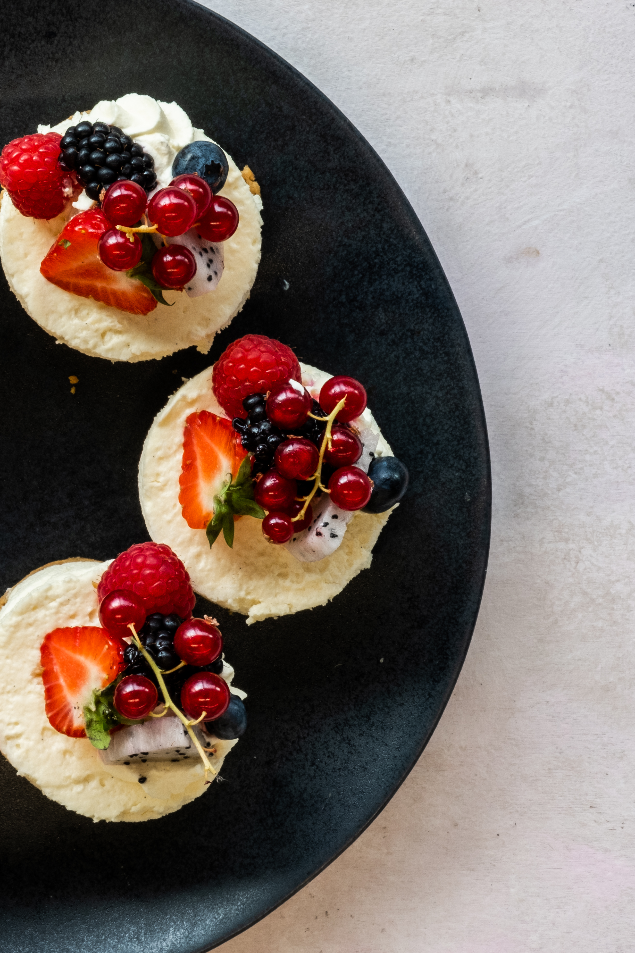 Elegant dessert platter with mini cheesecakes and berries for upscale events.
