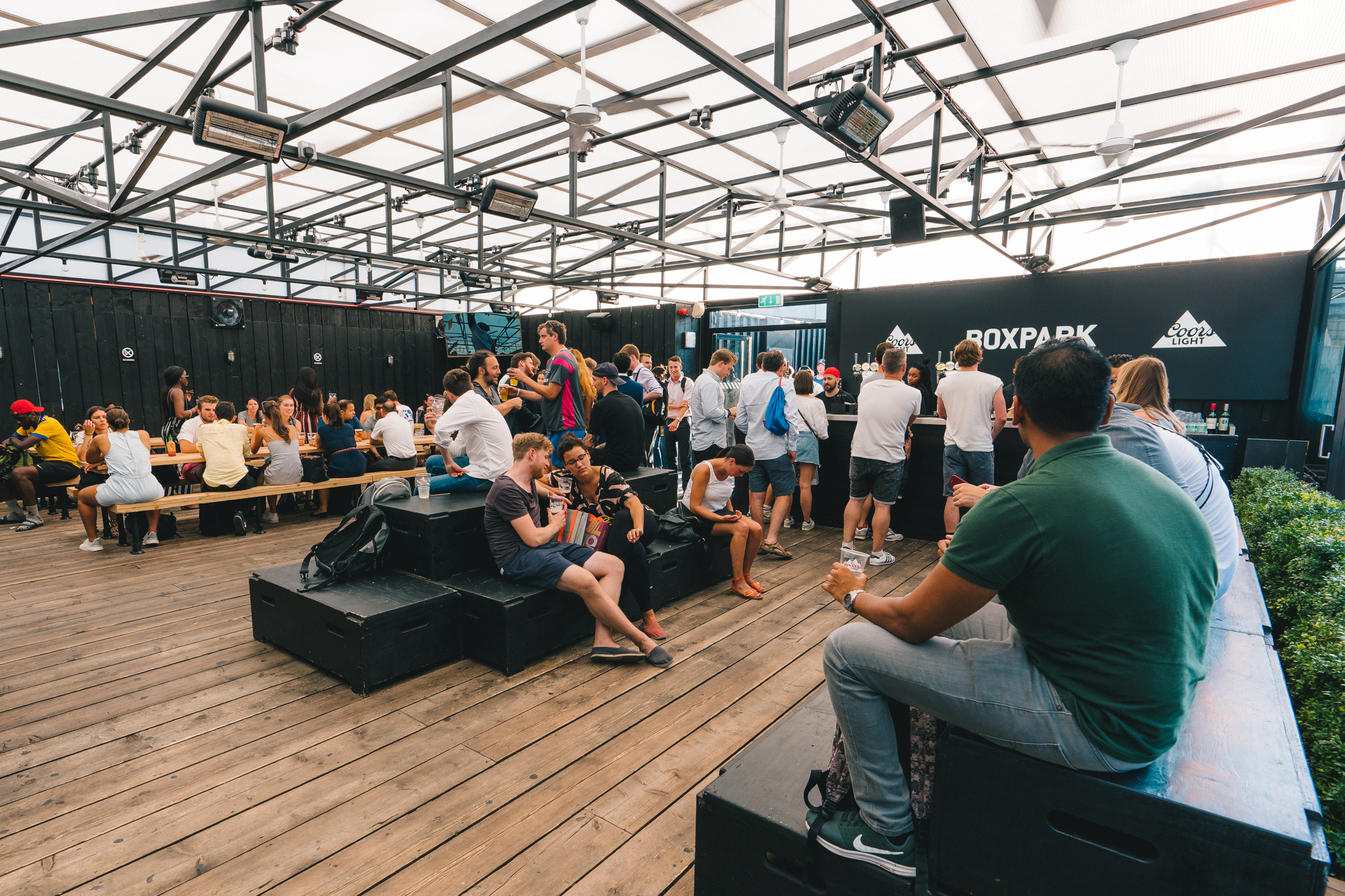 Vibrant networking event at Boxpark Shoreditch with casual seating and natural light.