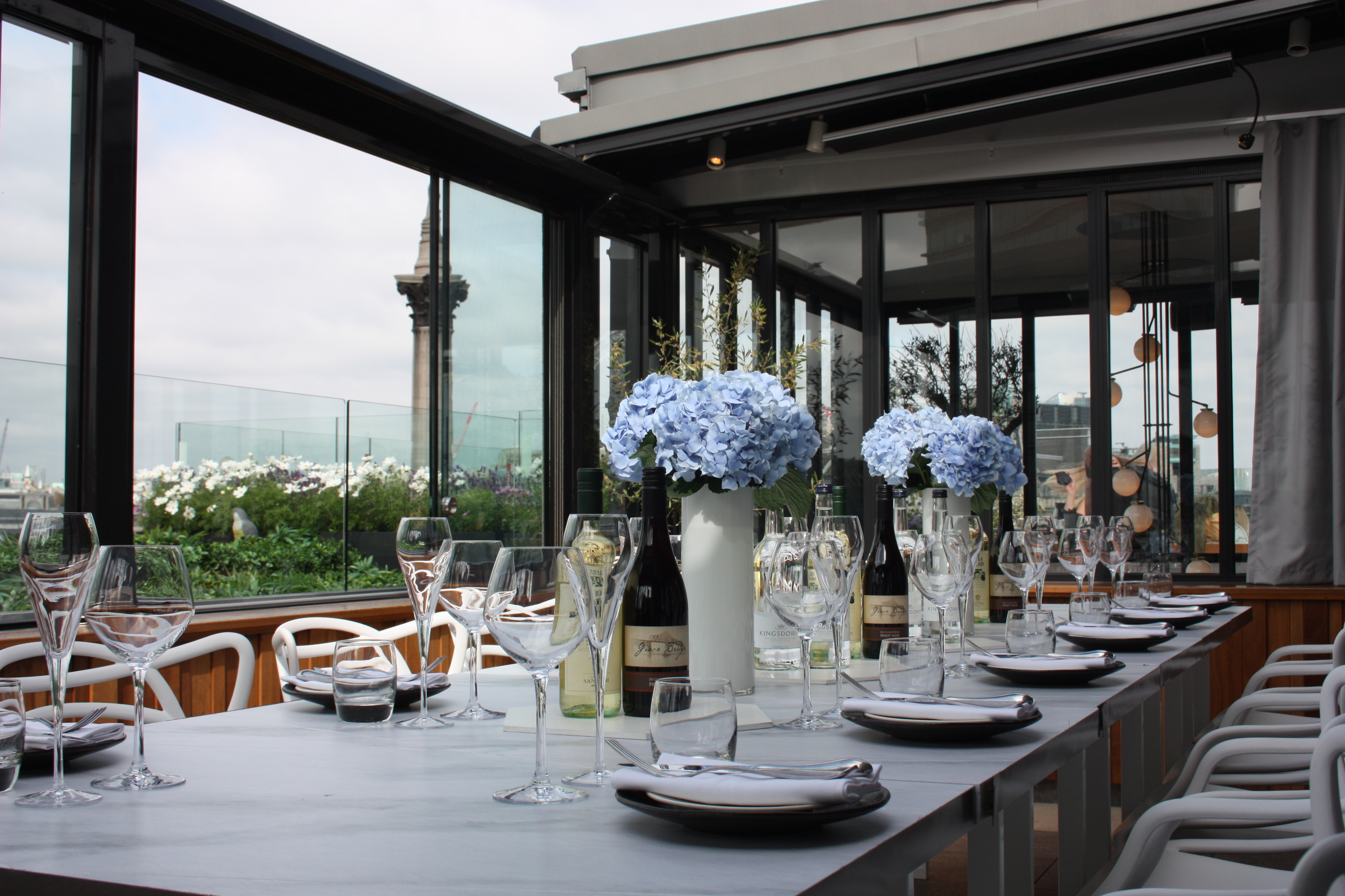Elegant dining table with floral arrangements at The Rooftop ROOM, Trafalgar St James.