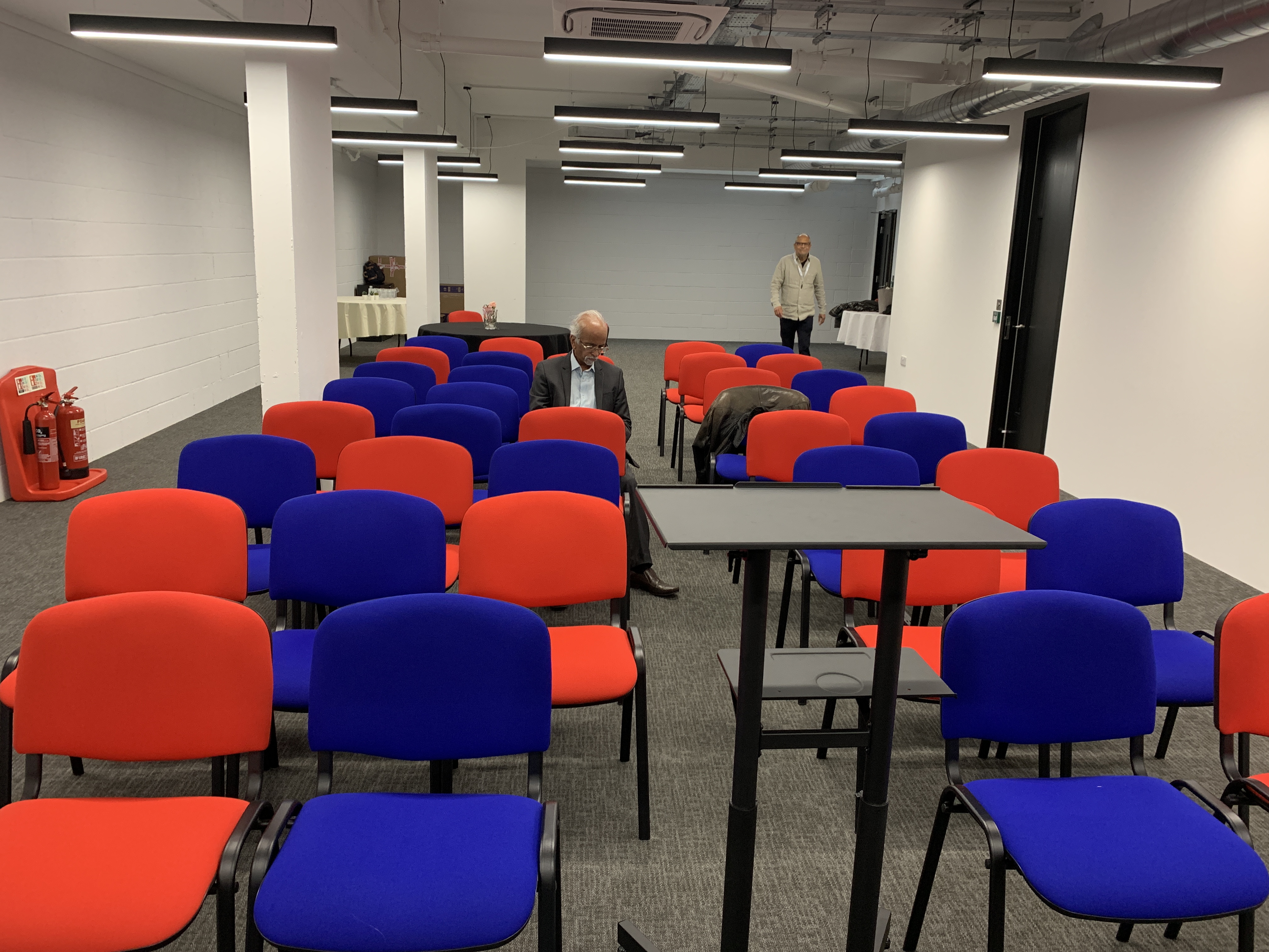 Vandon Rooms meeting space with red and blue chairs for events and networking opportunities.