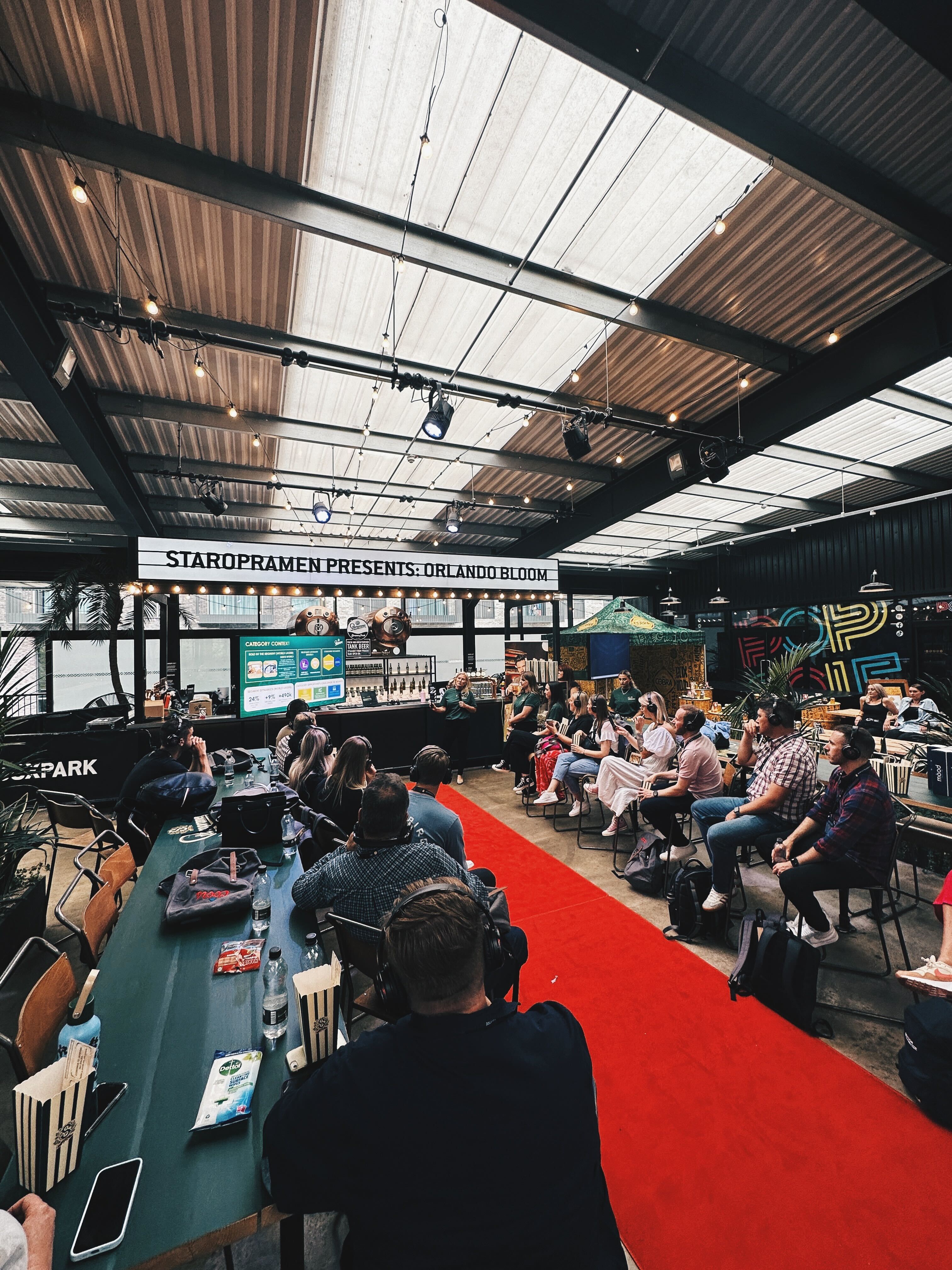 PlayBox Bar event space with audience in headsets for Orlando Bloom presentation.