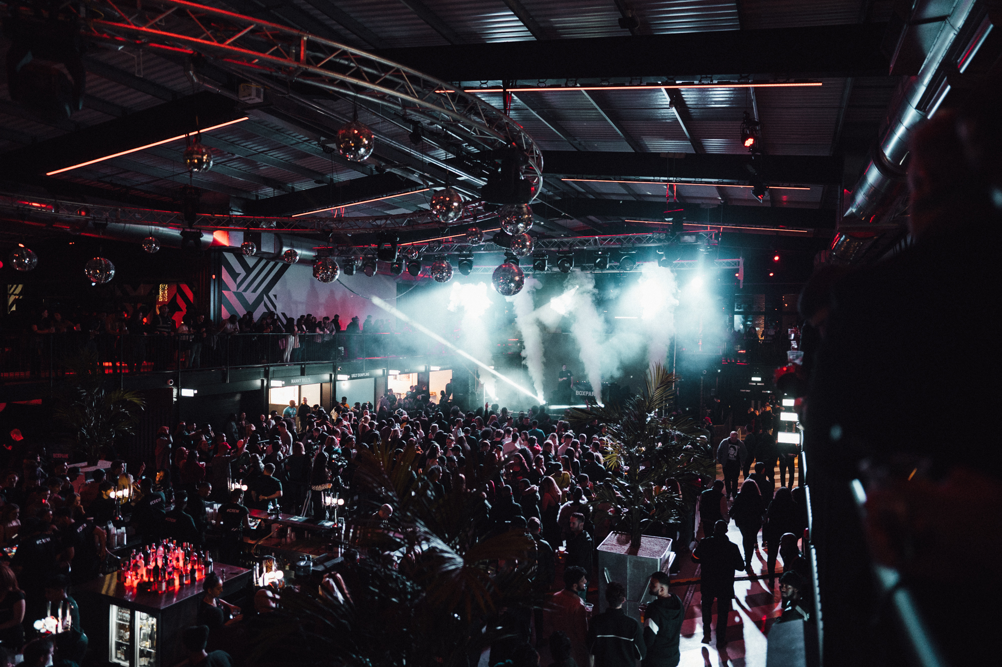 Vibrant event space at Boxpark Wembley with dynamic lighting for concerts and gatherings.