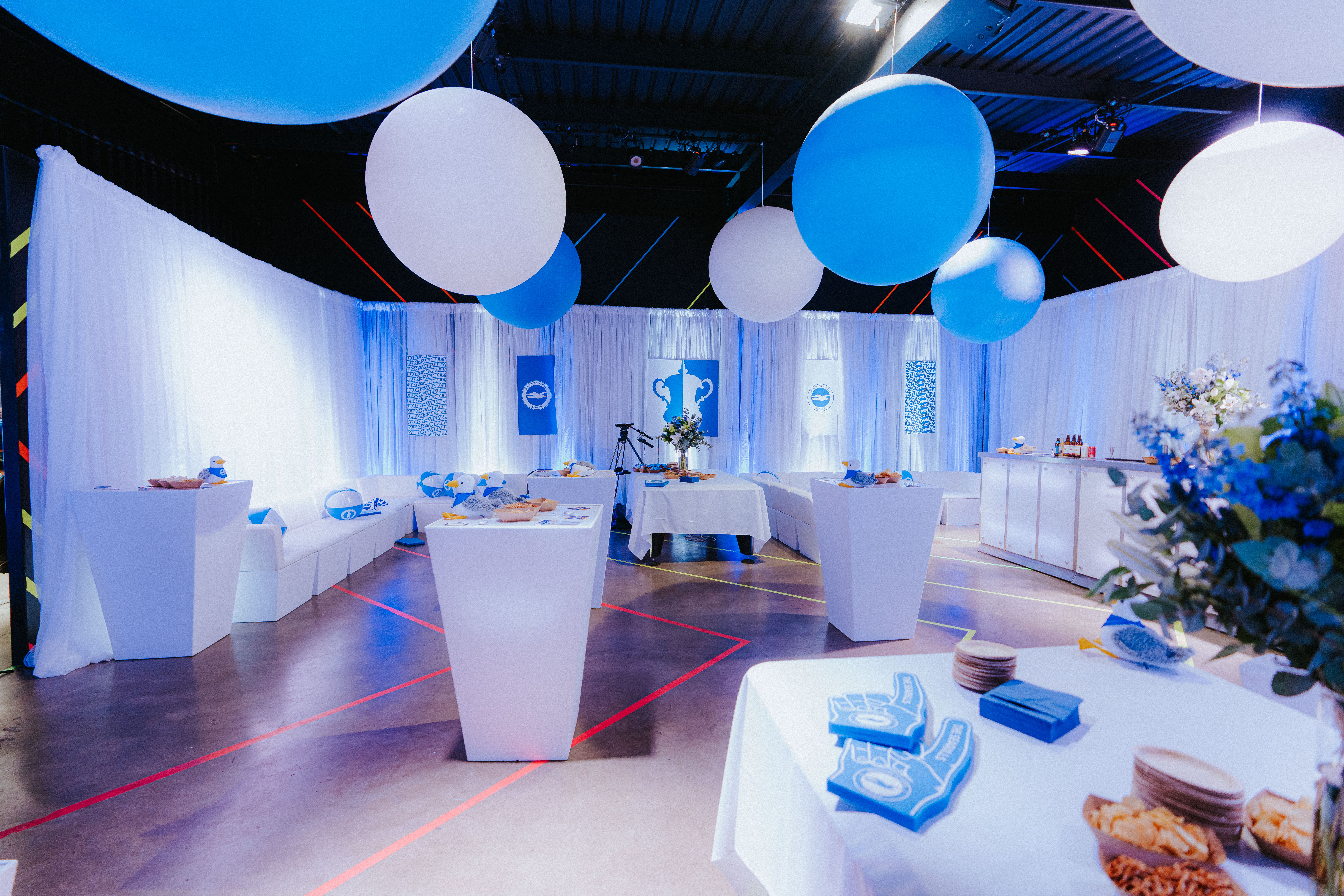Modern event space at Playbox Room, Boxpark Wembley with blue accents and balloons.