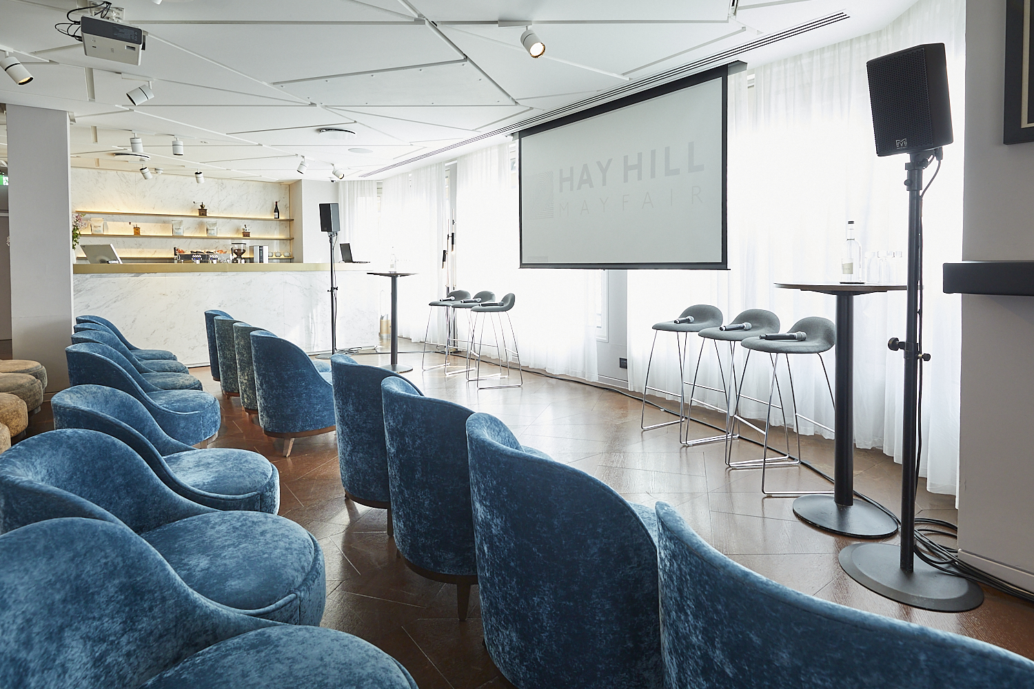 Modern meeting space with blue chairs for presentations and networking events at 12 Hay Hill.