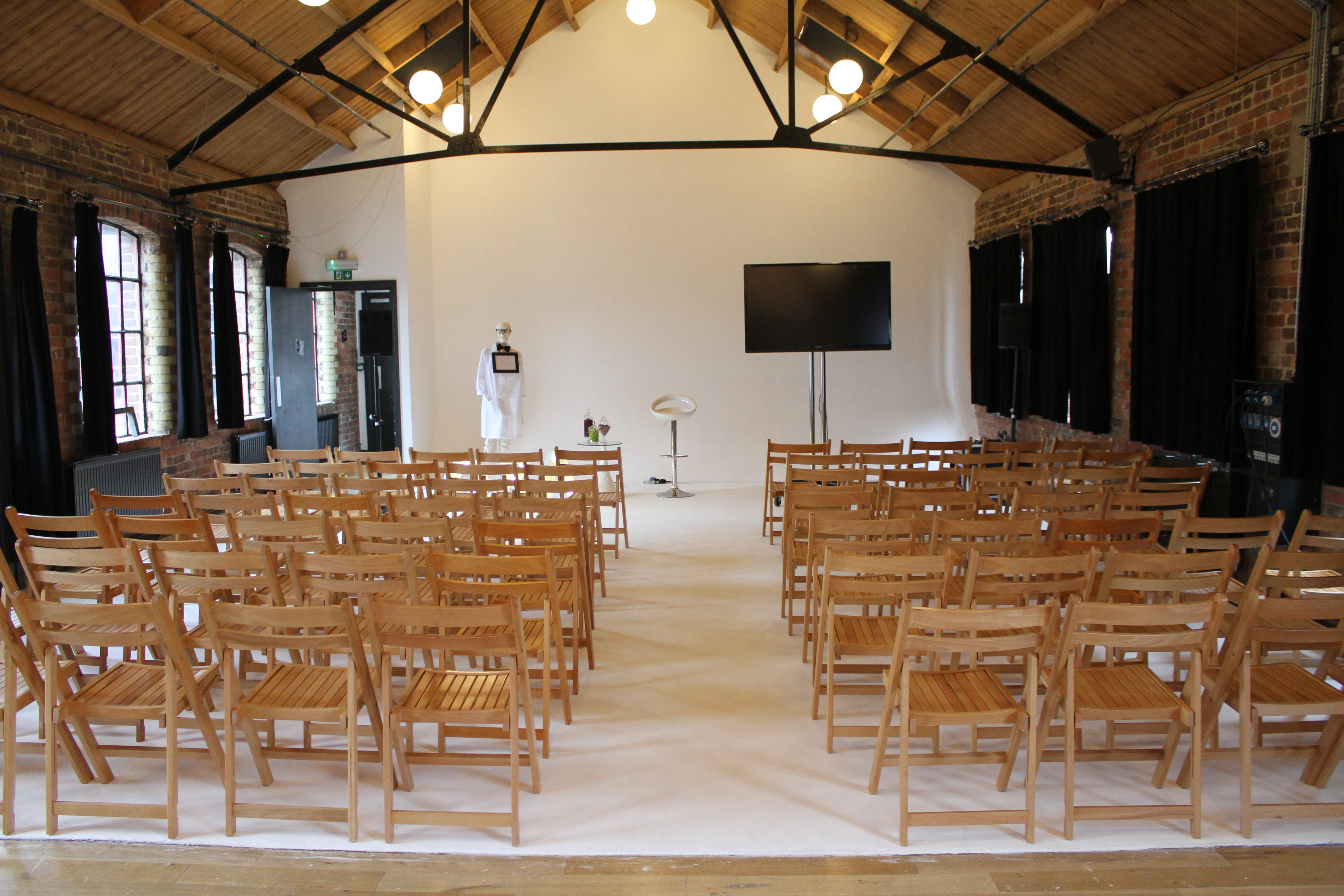 Versatile event space with wooden chairs for presentations and workshops at Loft Studios.
