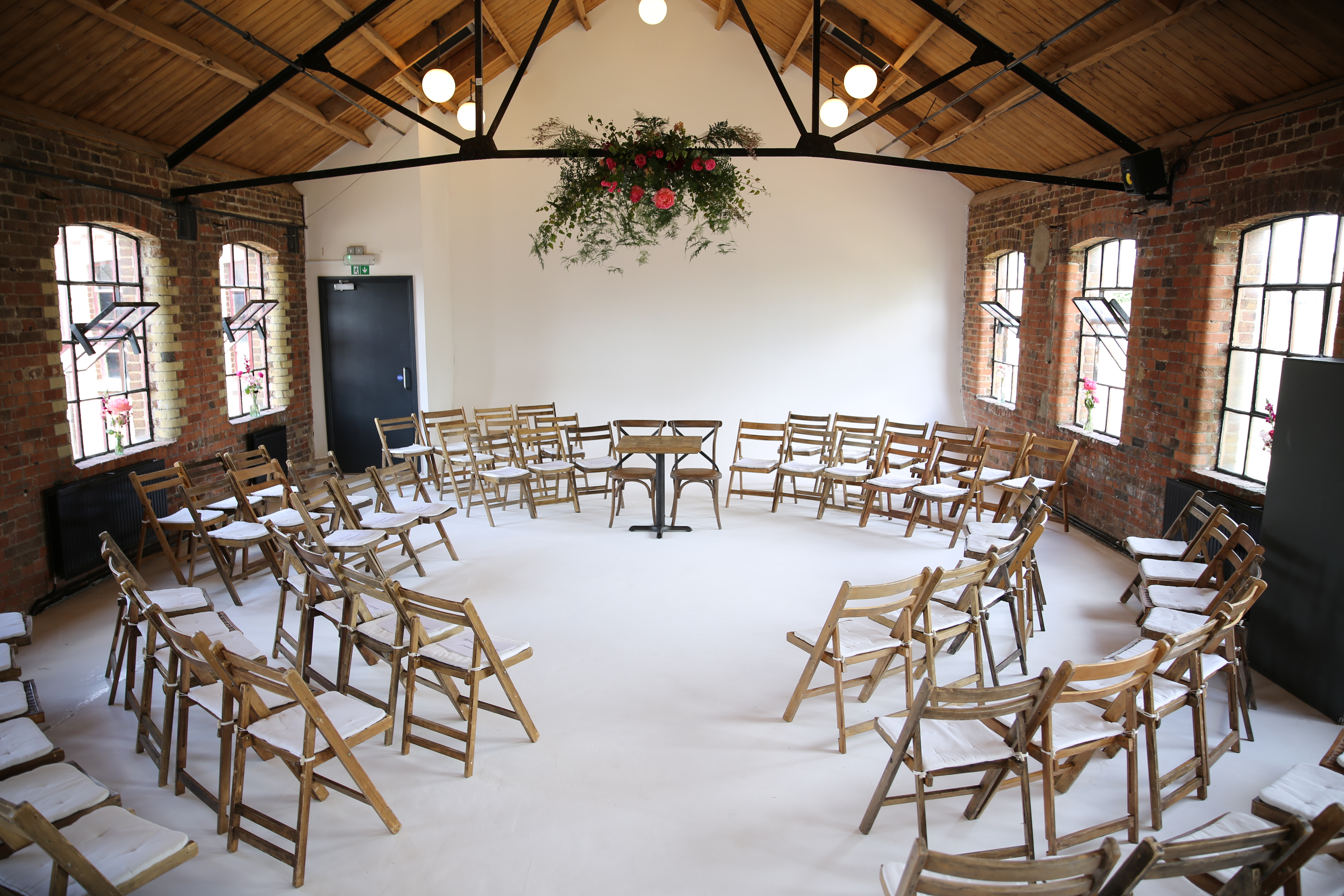 Versatile meeting space with wooden chairs, perfect for workshops and brainstorming sessions.