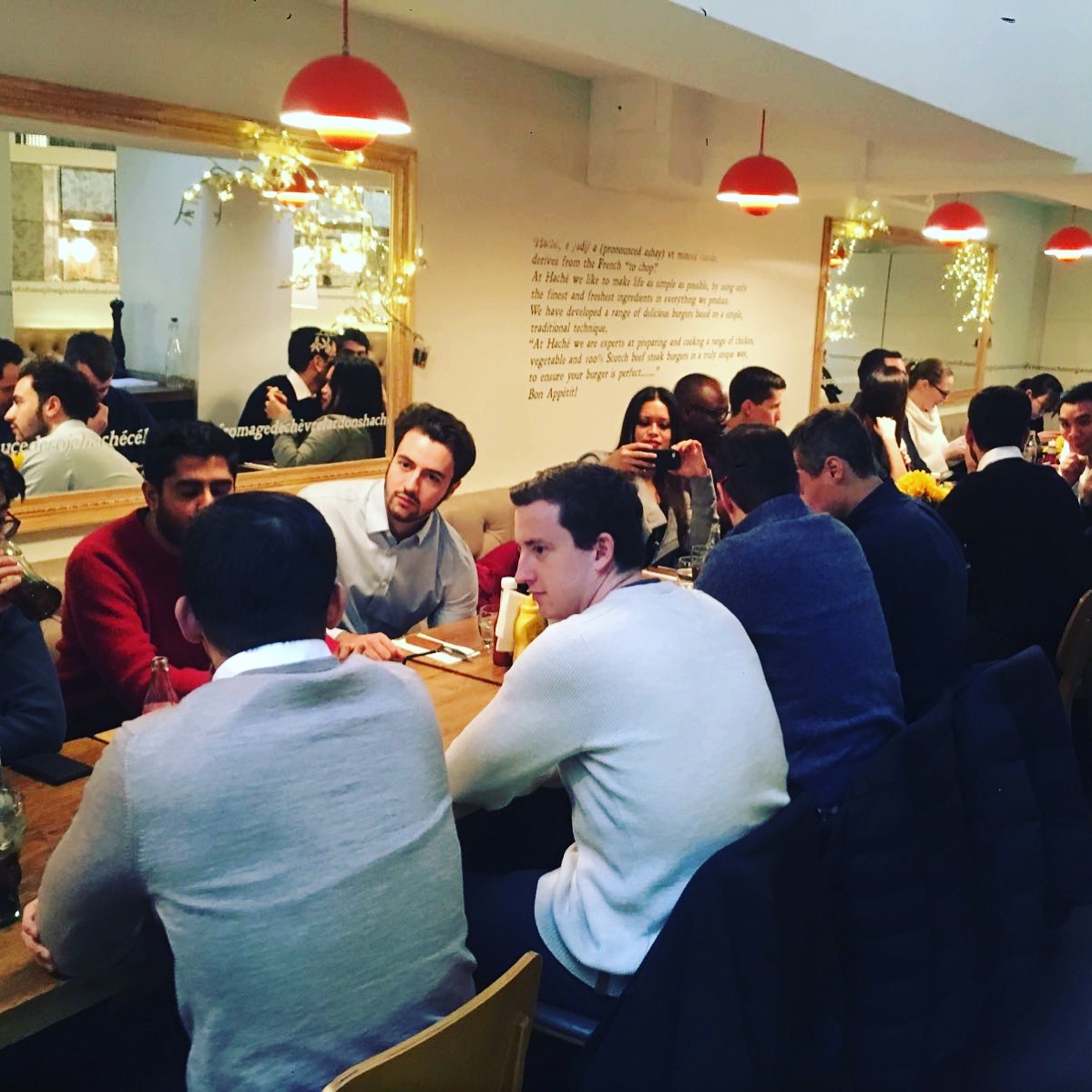 Lively group dining in Hache Holborn's Party Room, ideal for networking events.