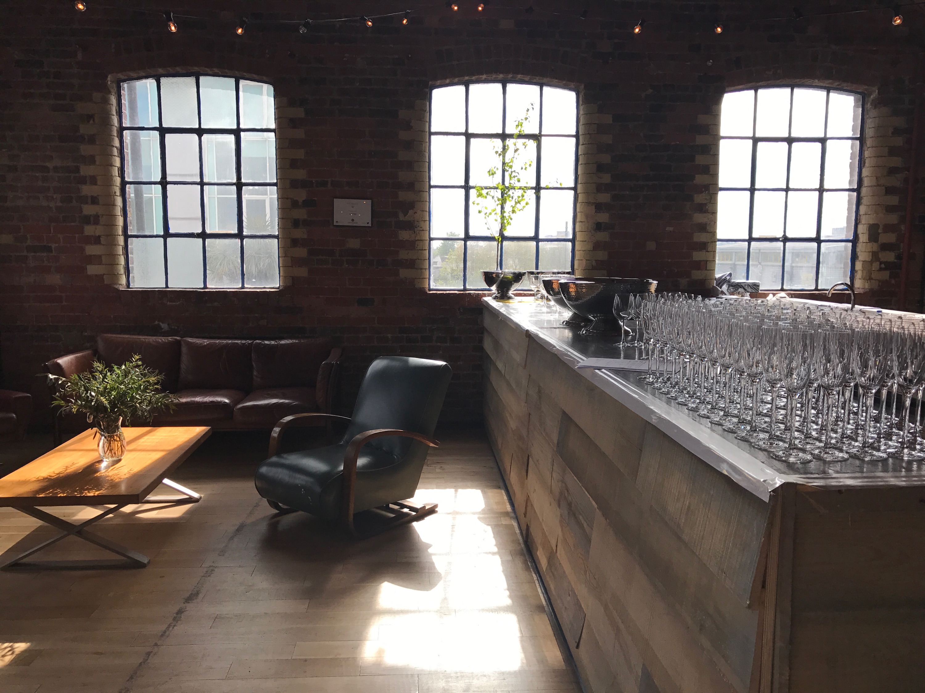 Stylish Loft Studios event space with large windows and rustic brick walls.