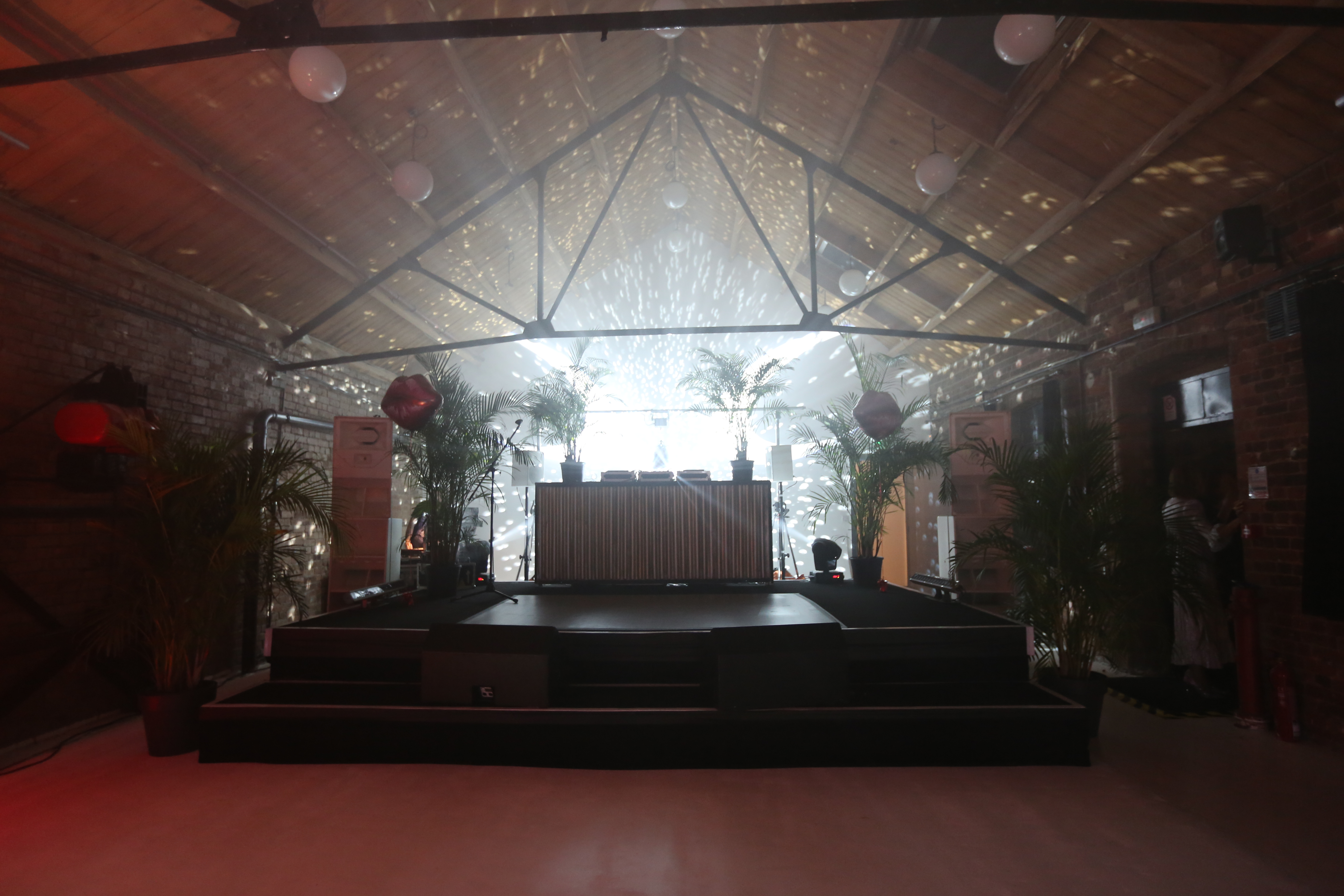 Stylish Loft Studios event space with raised stage, ideal for corporate and social gatherings.