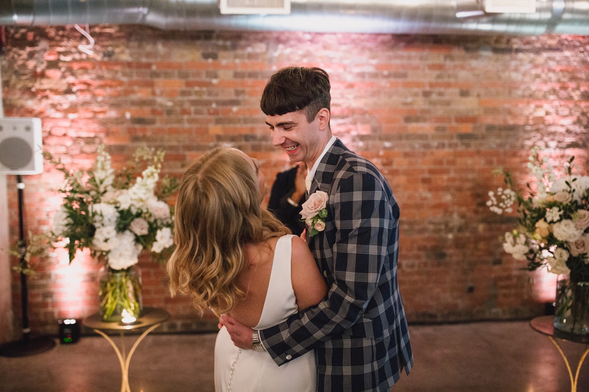 Couple in elegant venue with exposed brick, ideal for weddings and special events.