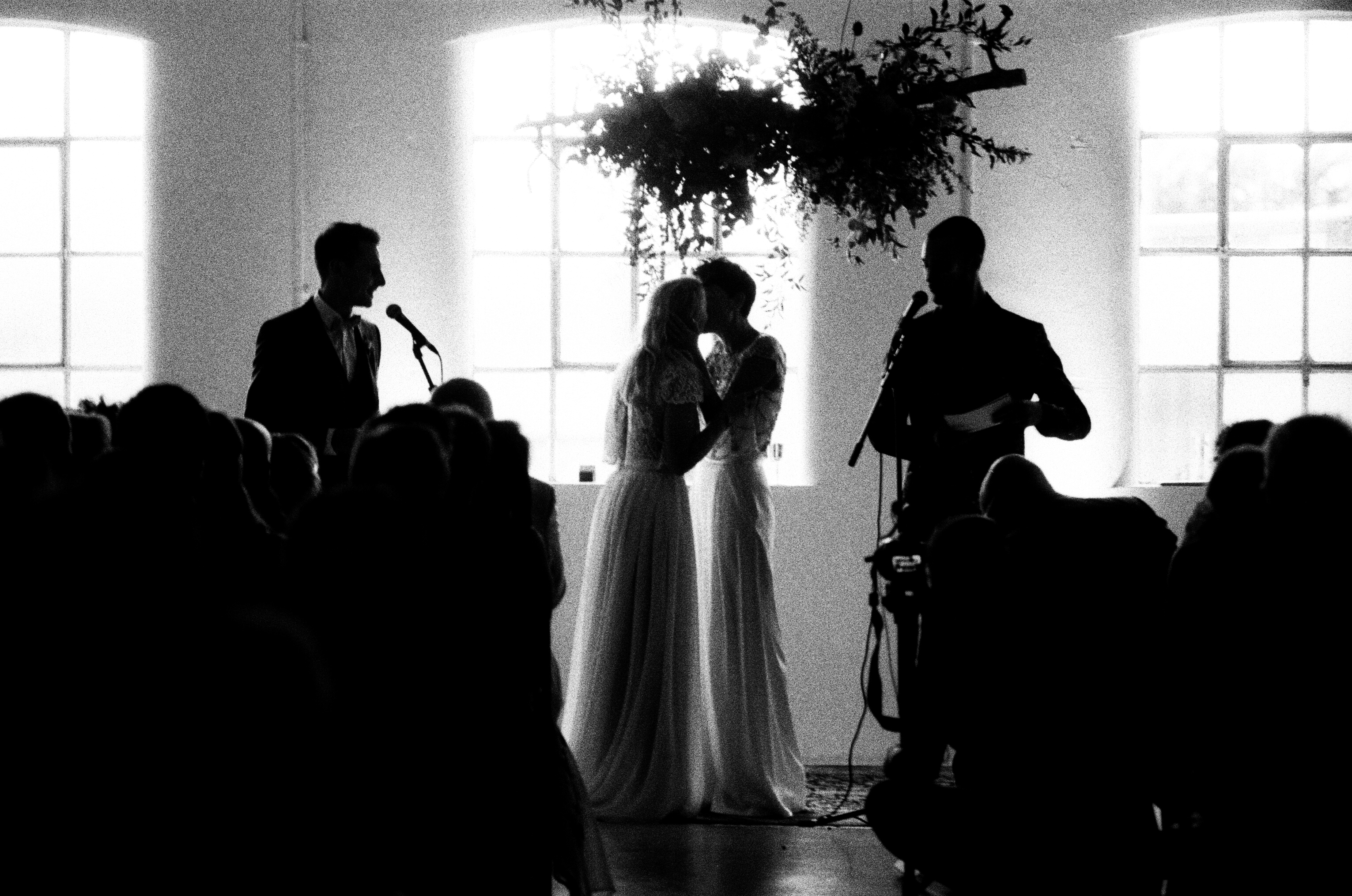 Intimate wedding ceremony in Studio 5, featuring a couple silhouetted with elegant floral decor.
