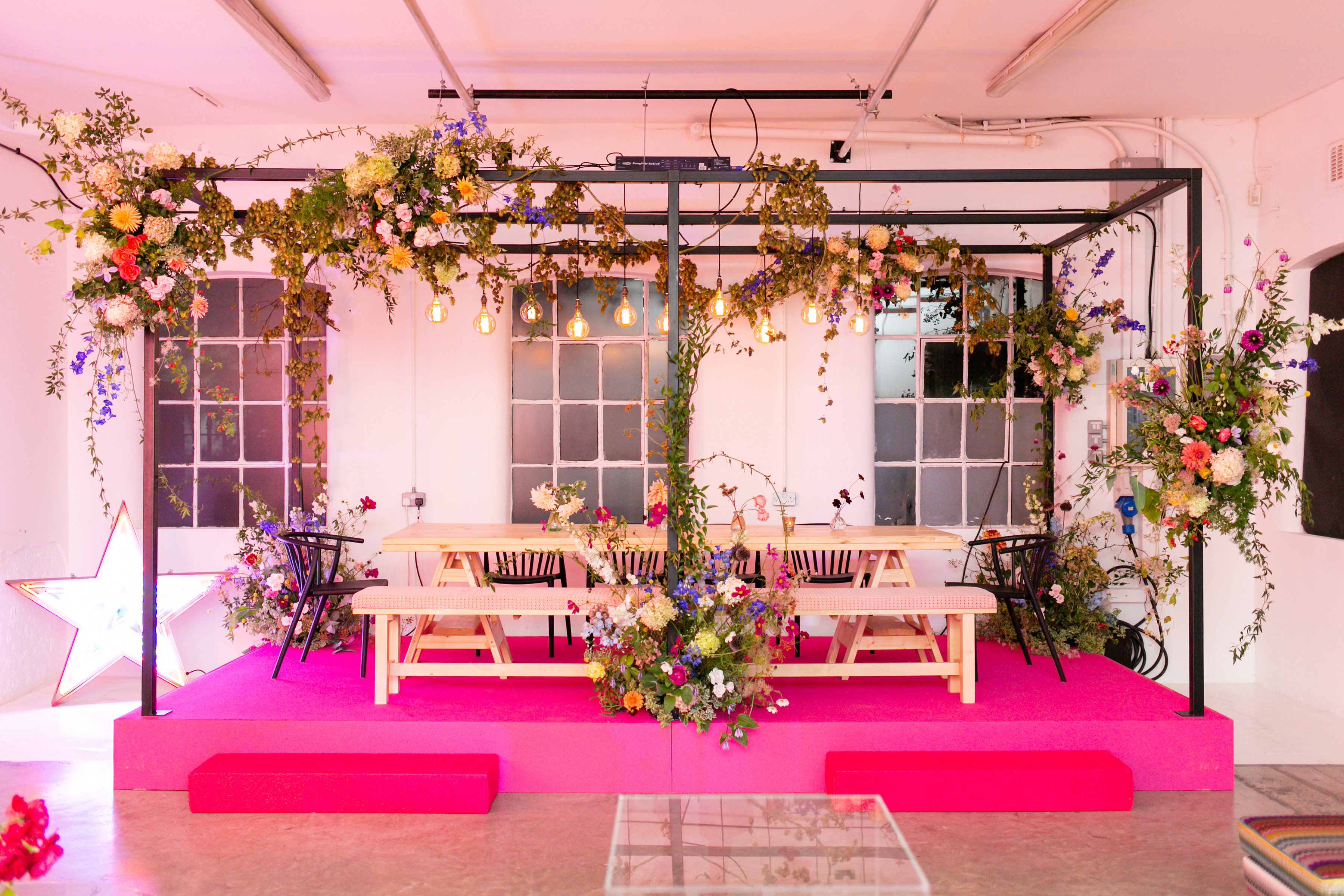 "Studio 5 event space with pink platform, floral decor for intimate gatherings."