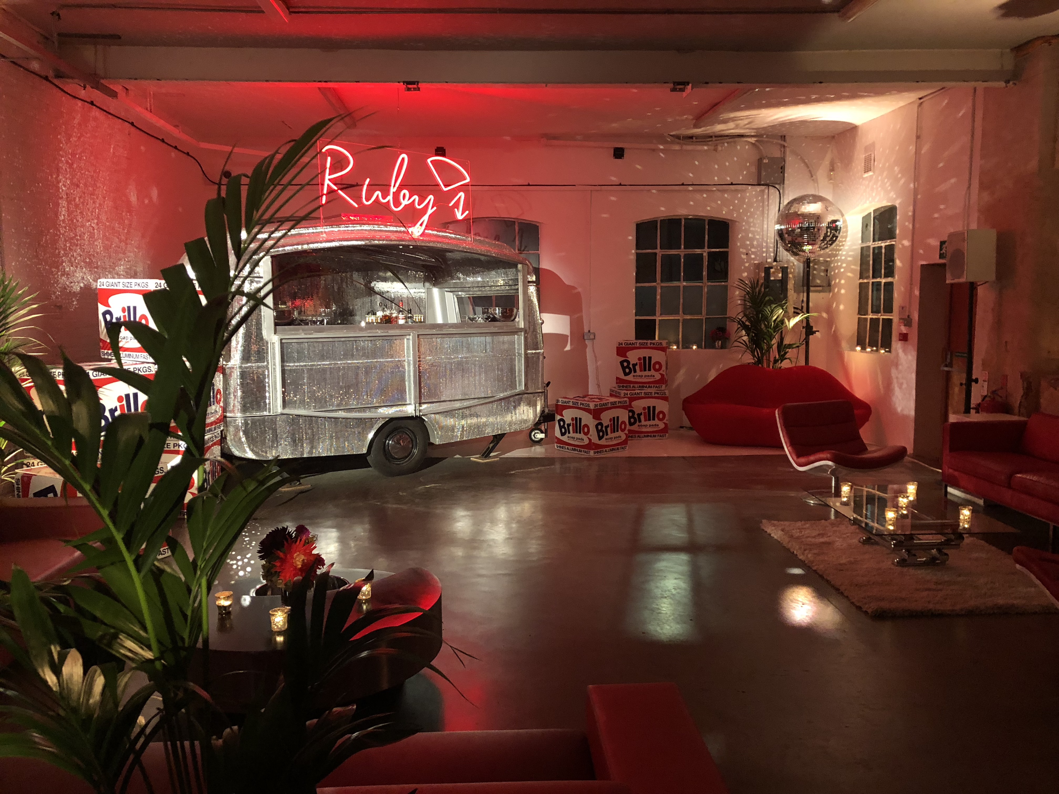 Stylish Loft Studios event space with vintage food truck and modern seating for gatherings.