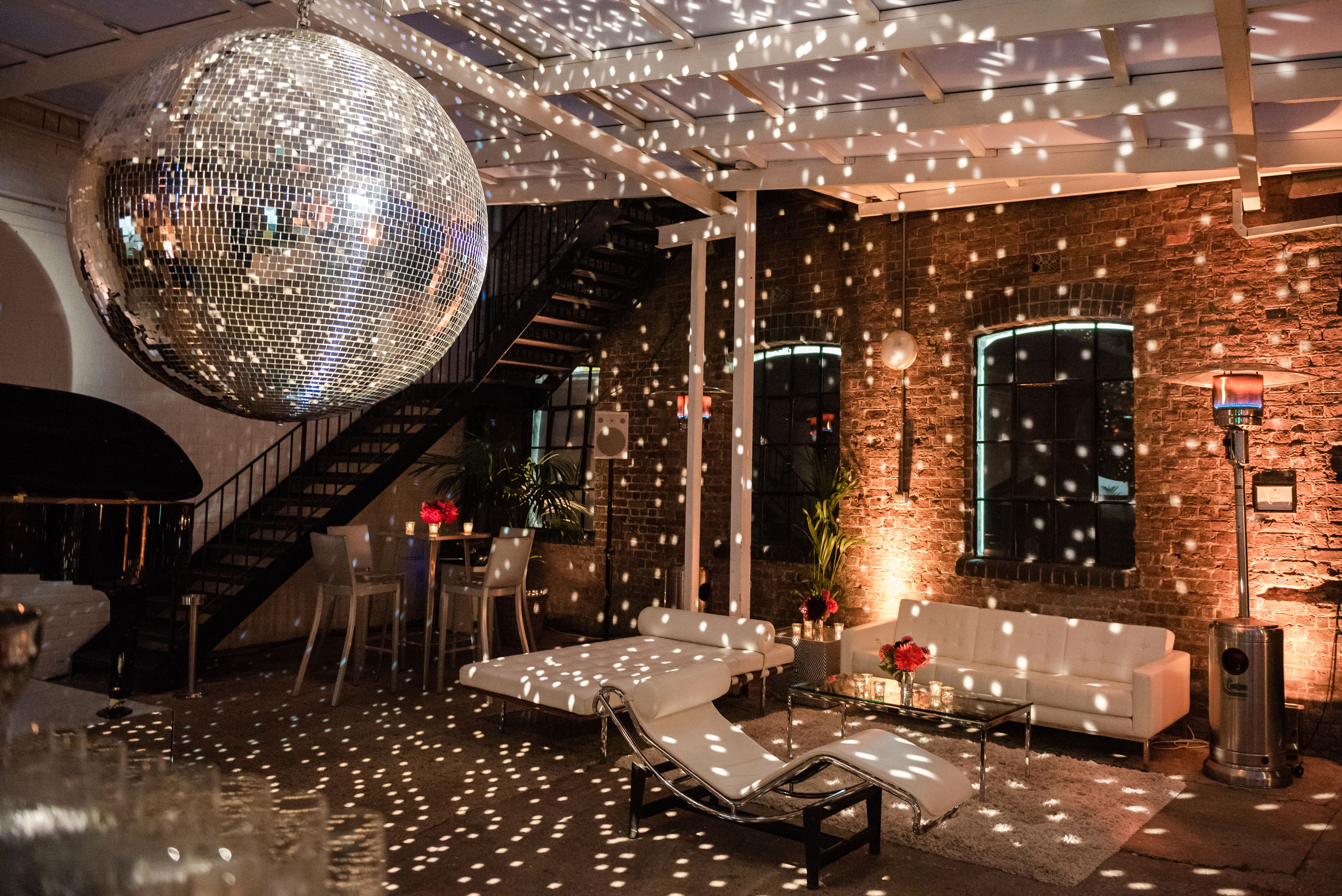 Stylish Loft Studios event space with a large disco ball for festive gatherings.