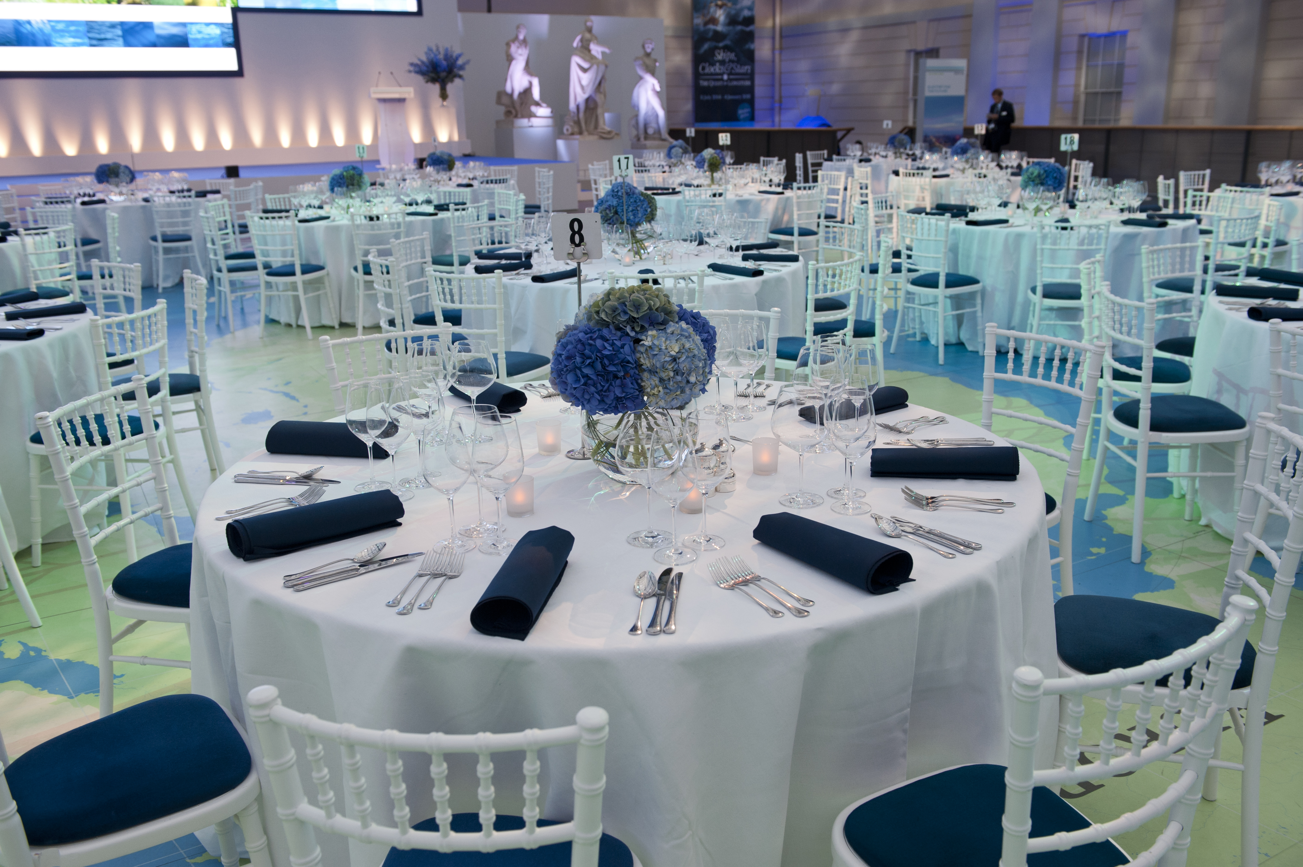 Elegant event space with blue flower centerpieces at National Maritime Museum.