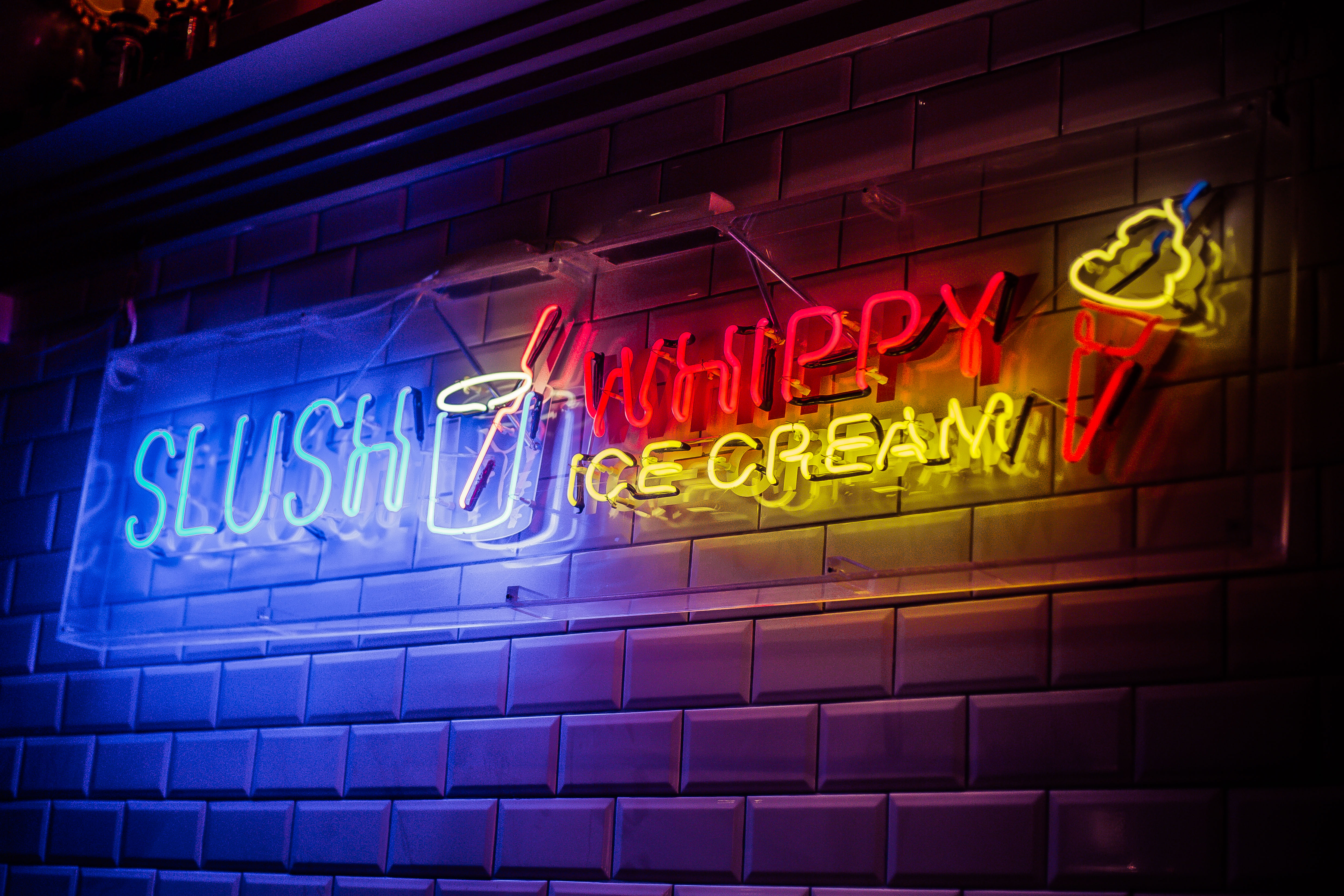 Vibrant neon slush and ice cream sign at Simmons Oxford Street for fun events.