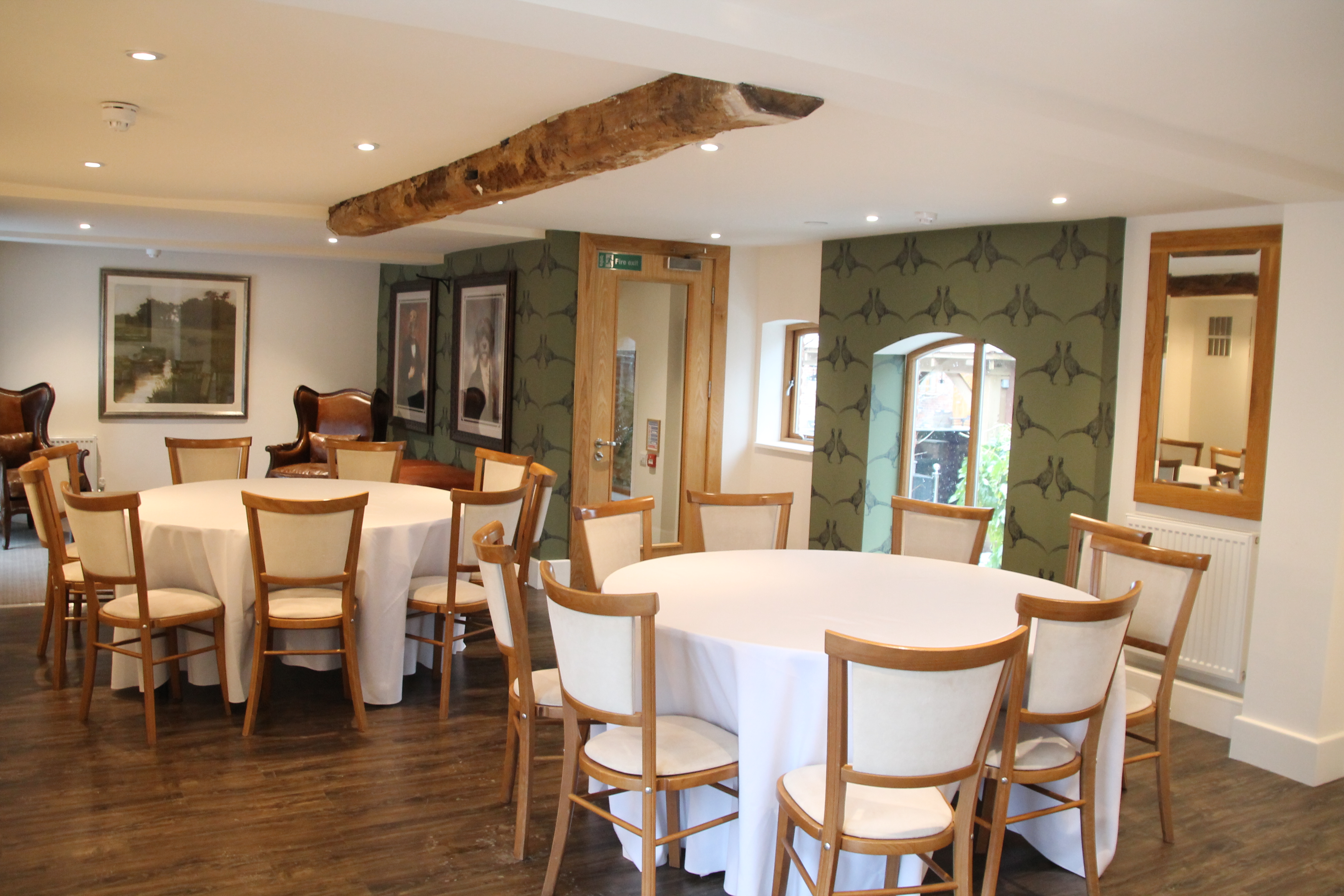 Versatile Mythe Barn stable with round tables, ideal for workshops and intimate gatherings.