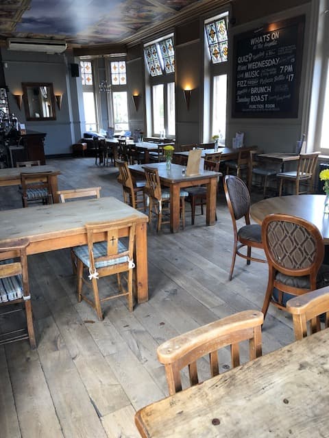 Spacious meeting room with rustic decor, ideal for gatherings and events at The Angelic.