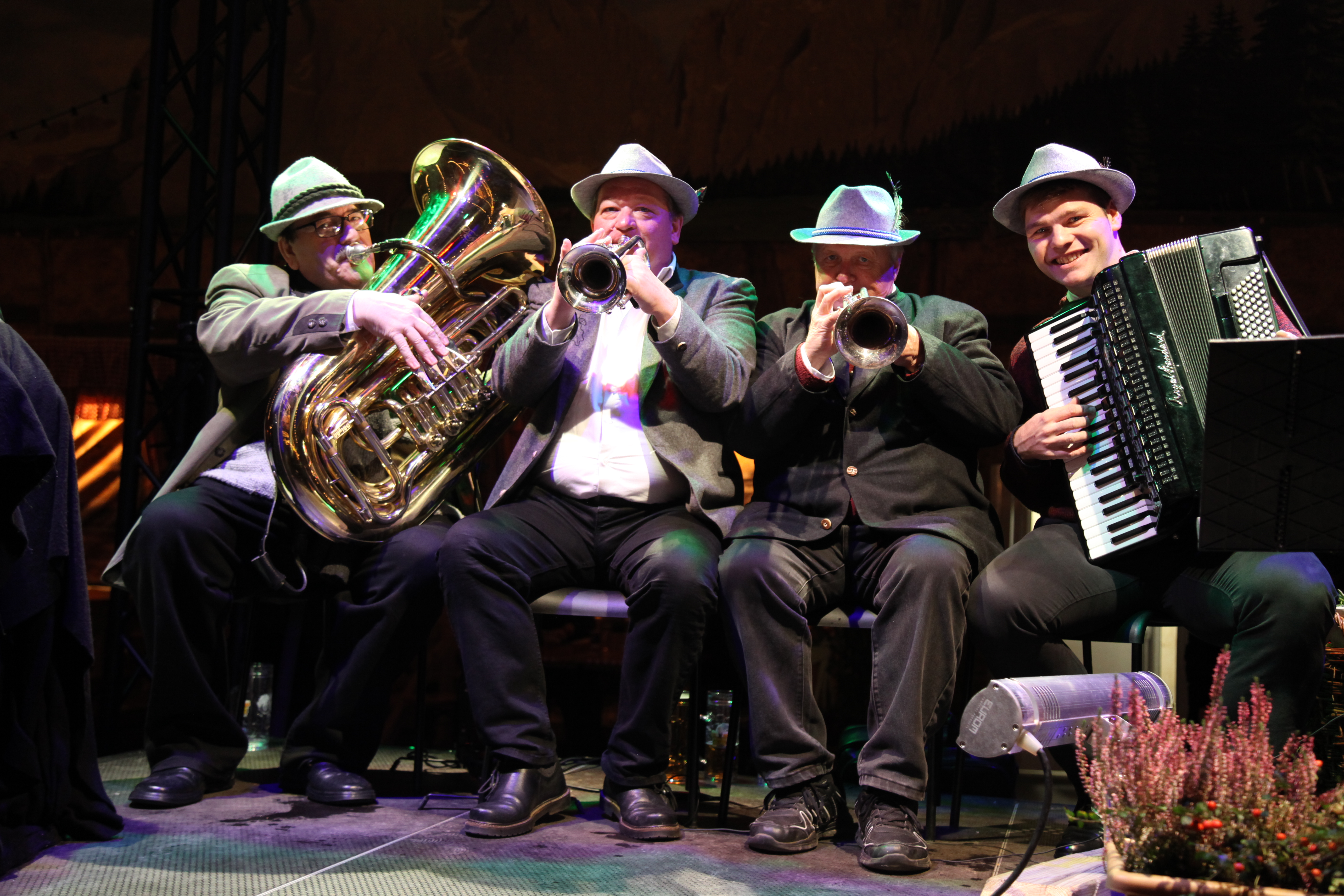 Lively Bavarian musicians with instruments at a festive event in Almhütte.